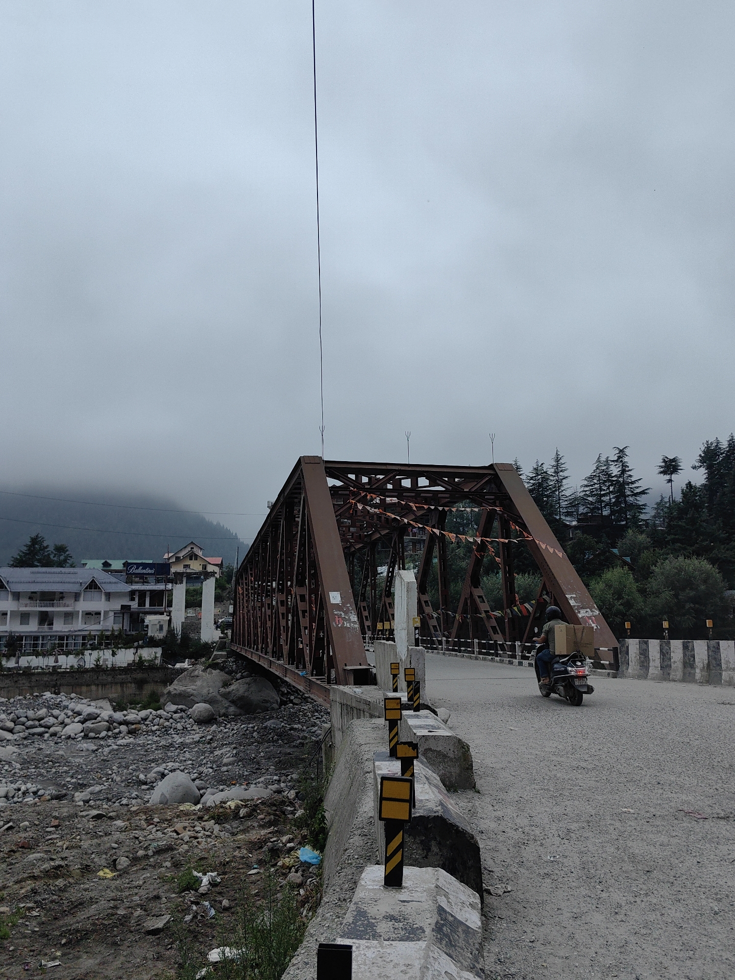 Rocky river valley with road traffic and construction activity, Himachal Pradesh