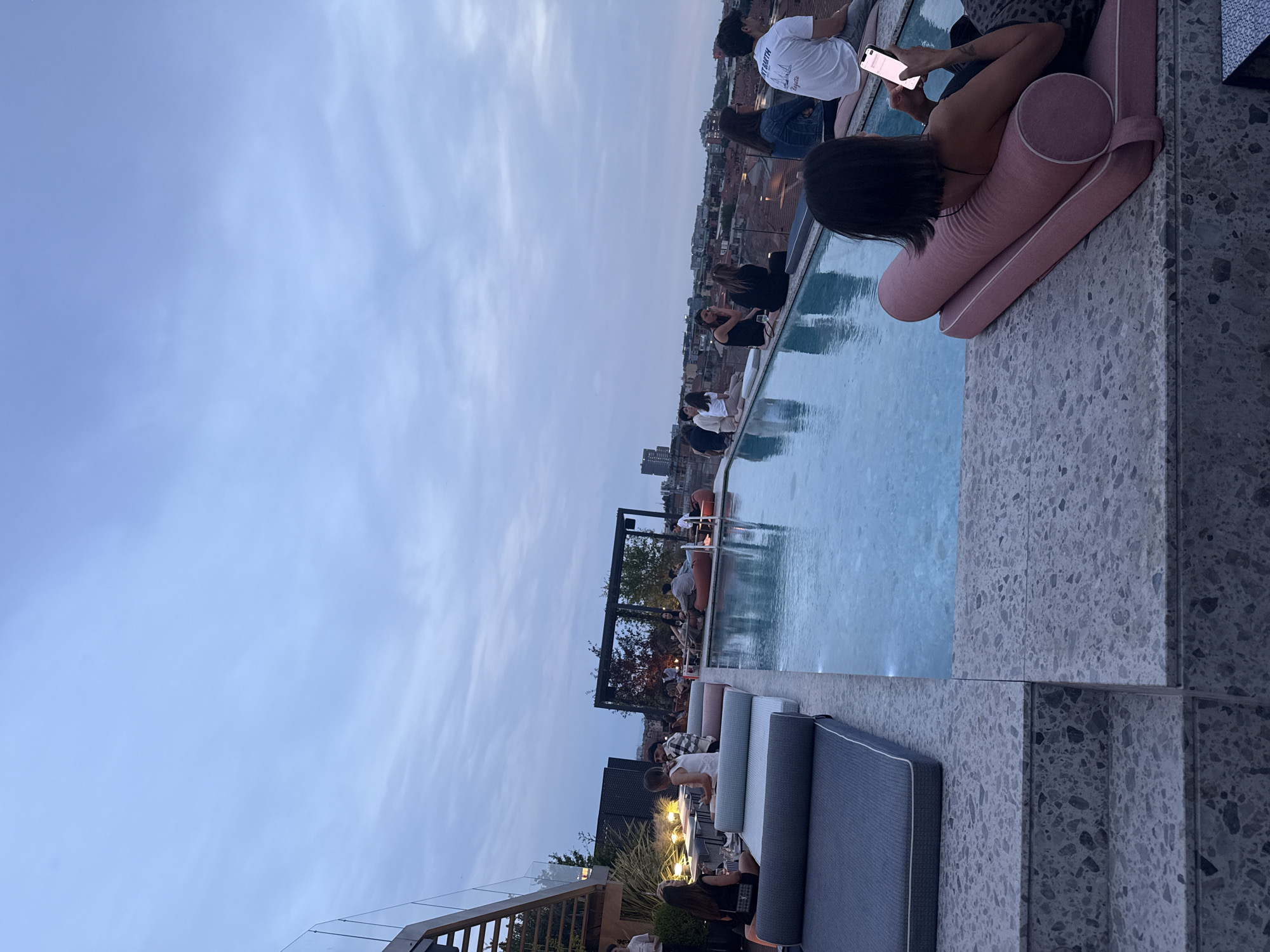 Evening rooftop pool party documented across Milan skyline