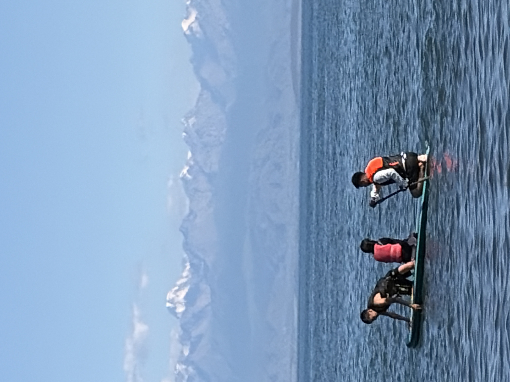 Mountain lake beach day: paddleboards, horses, and snow-capped peaks