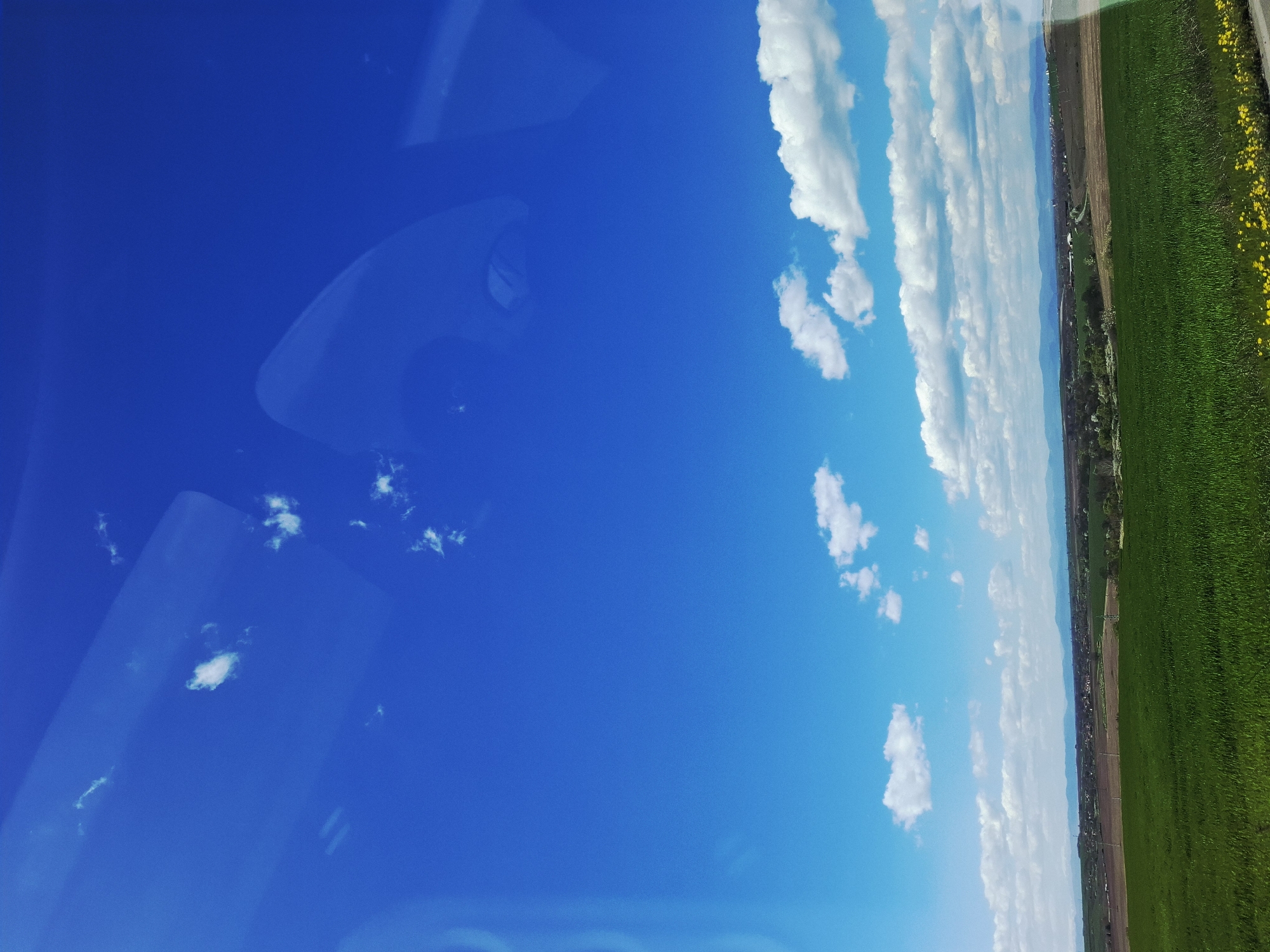 Roadside spring scene documented with leafless trees, blue skies