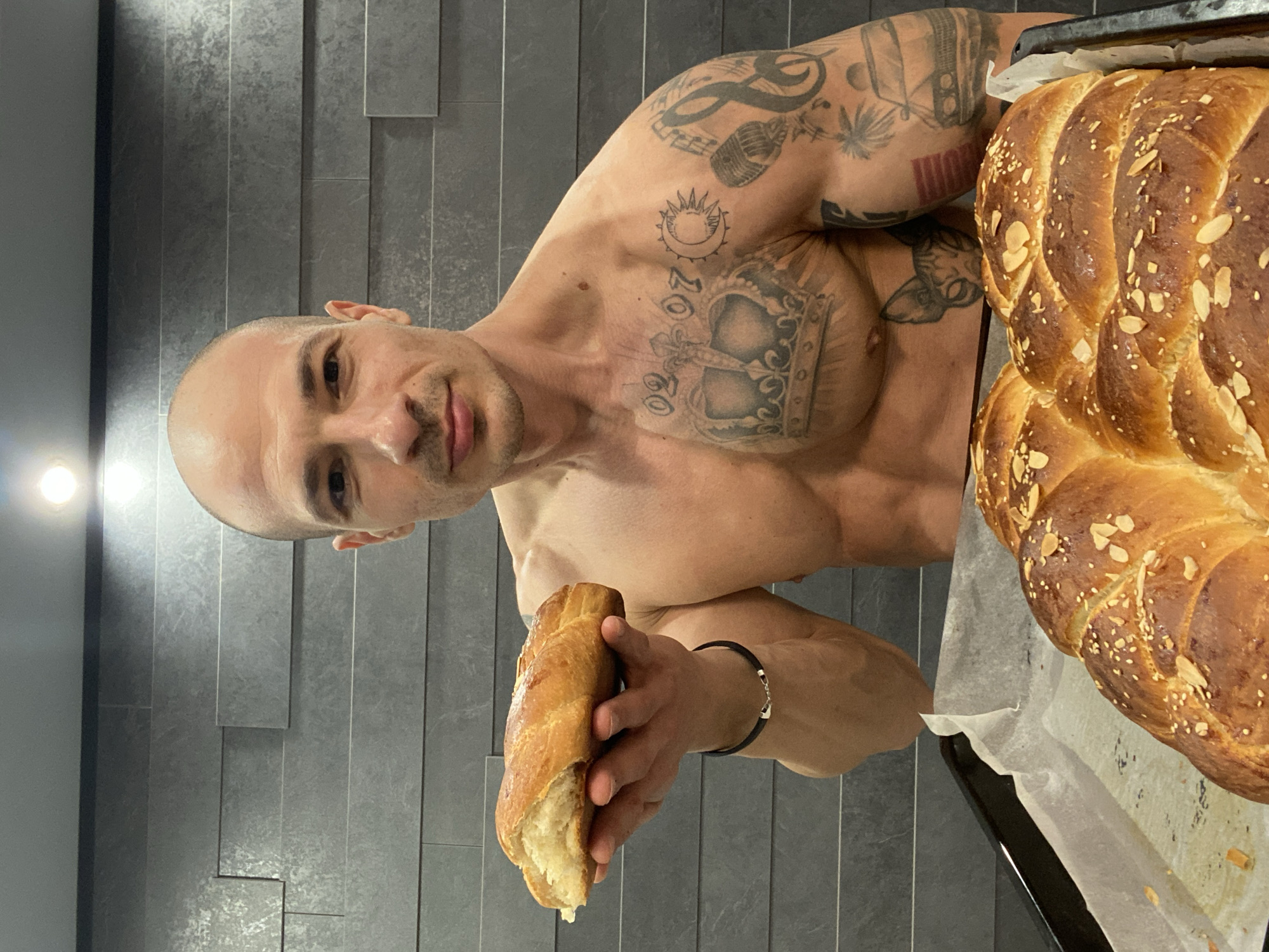 Tattooed baker displays fresh bread in Pleven