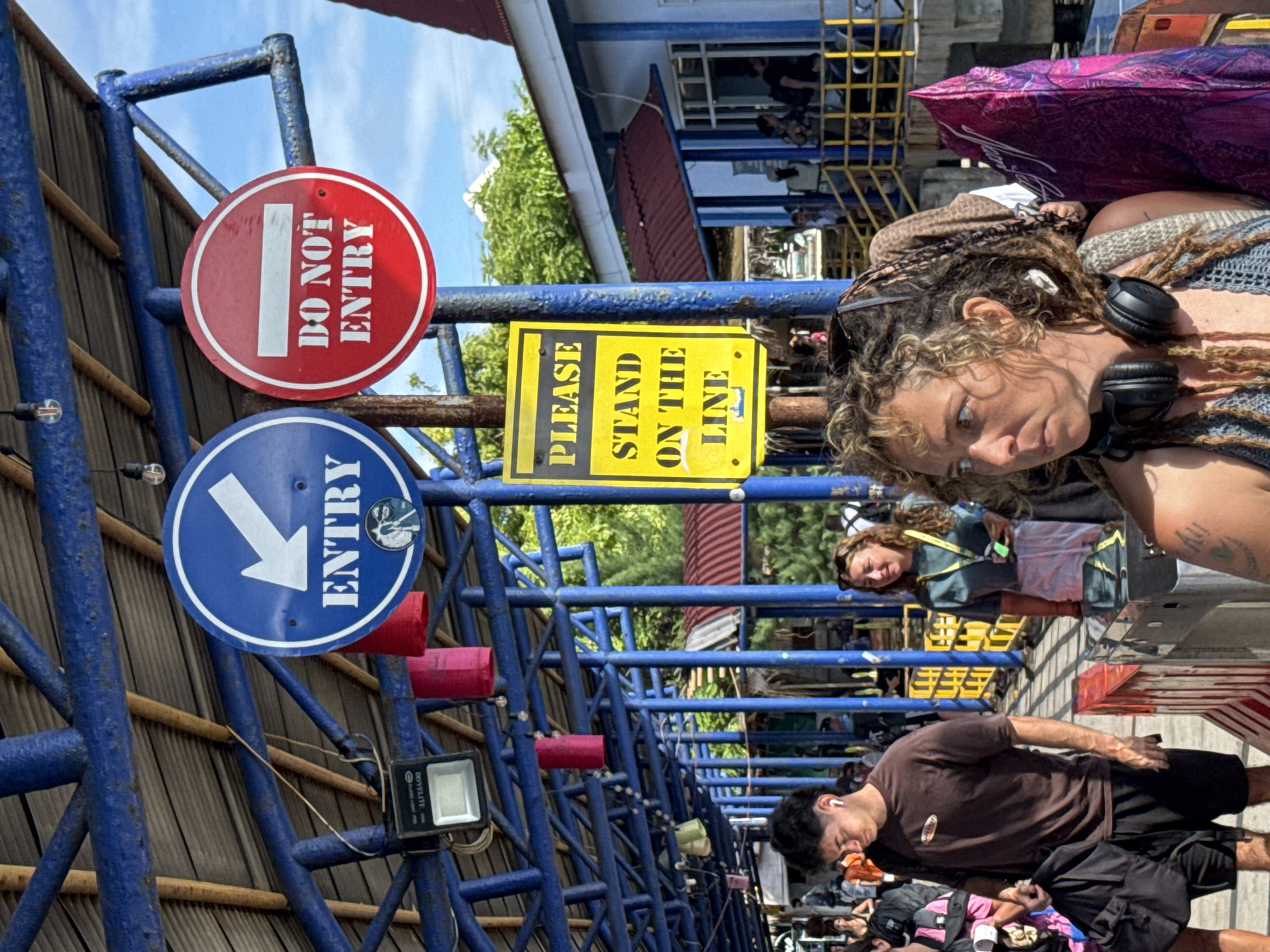 Outdoor queuing area with blue barriers observed in Indonesia