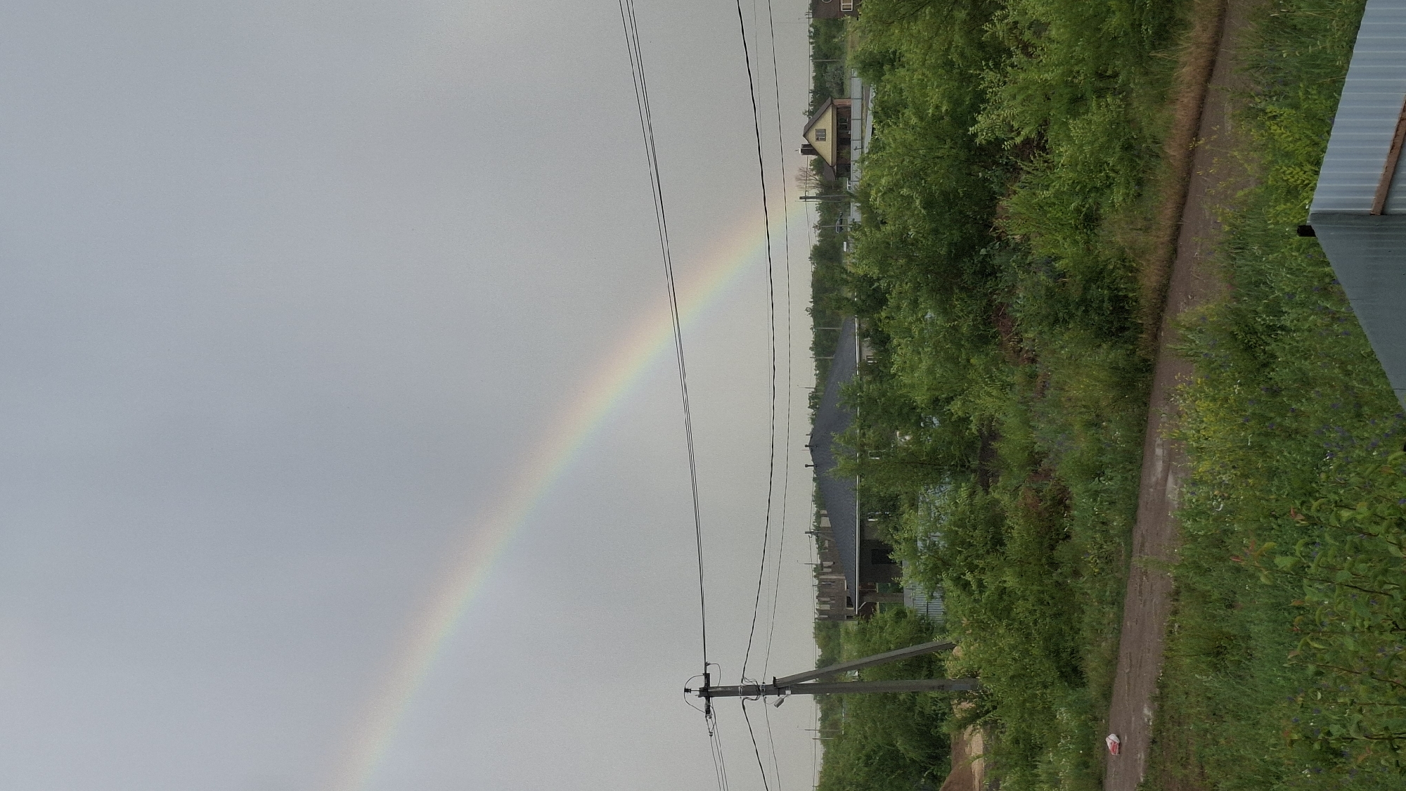 Rainbow over rural Engels under a cloudy summer sky