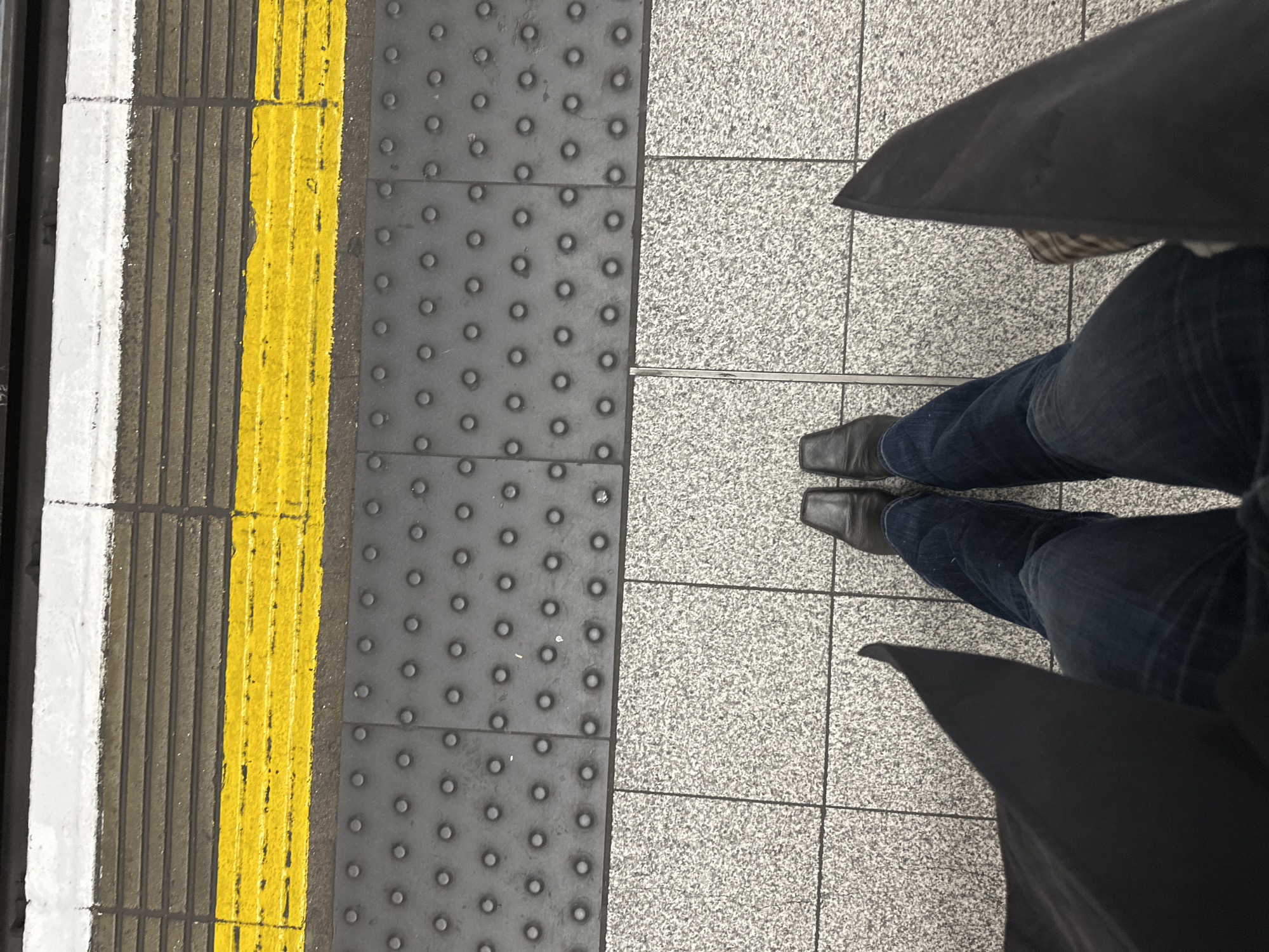 Commuter waits on London Underground platform during morning hours