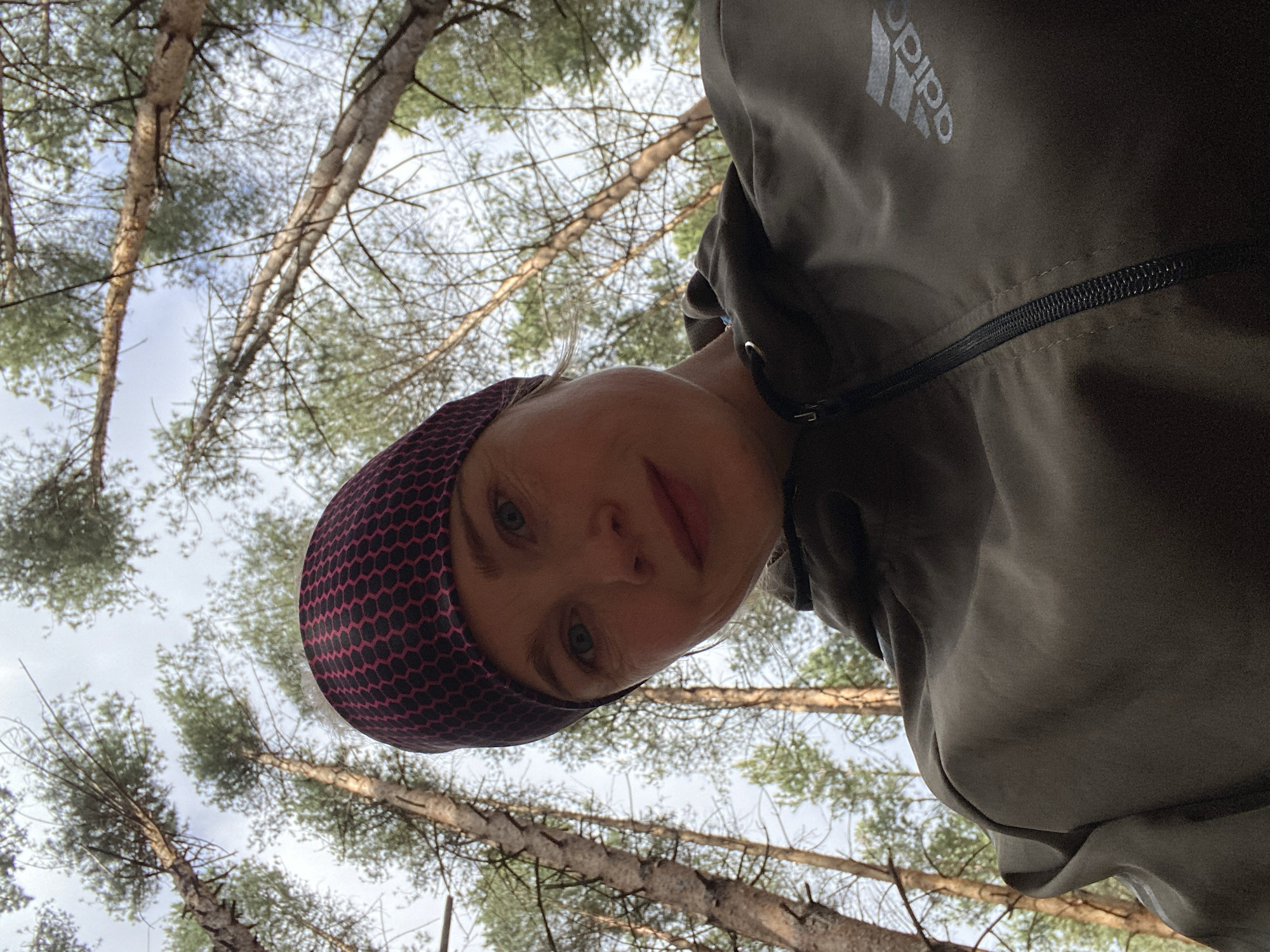 Woman takes early morning selfie in Russian pine forest