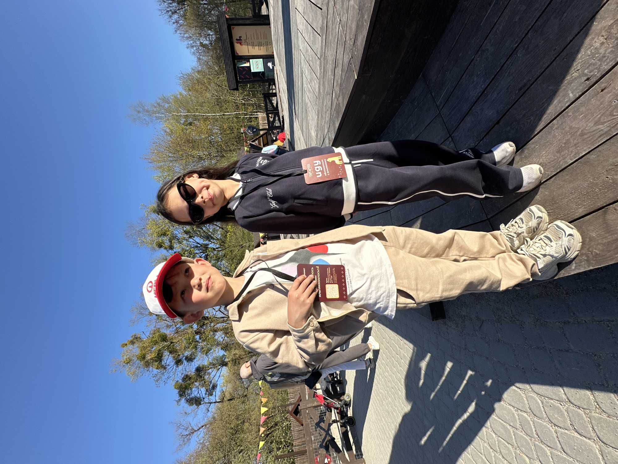 Two children pose together on wooden deck