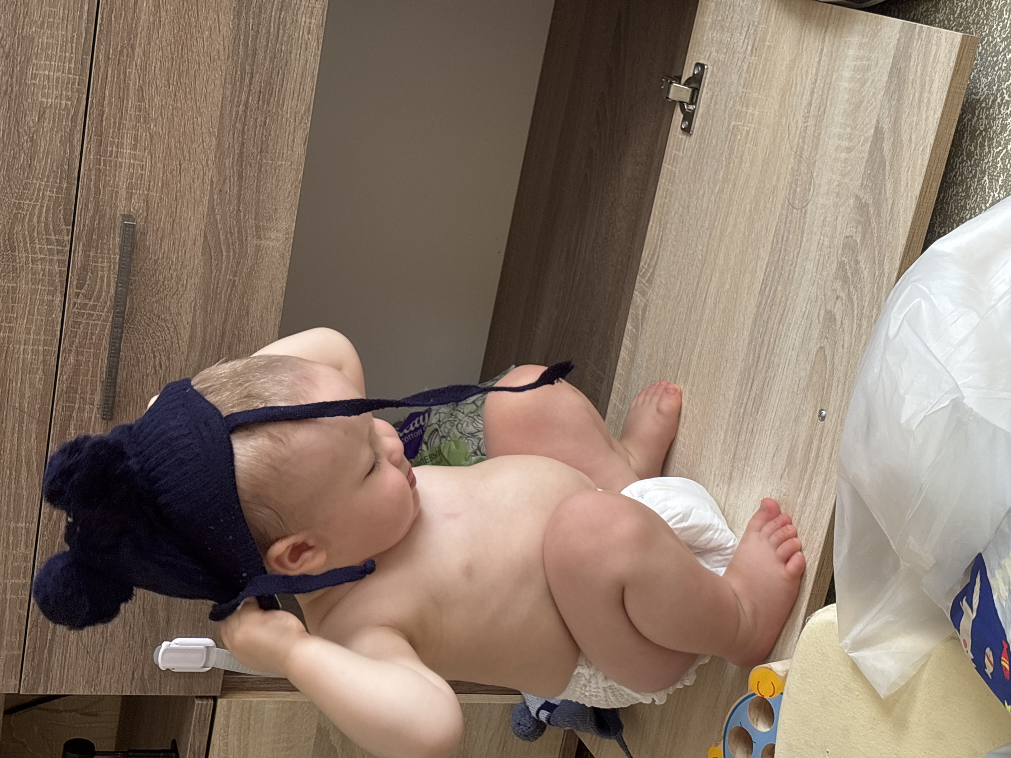 Toddler explores furniture while selfies are taken nearby