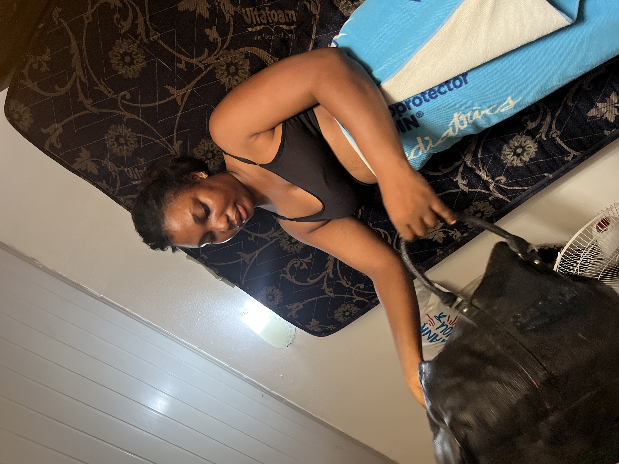 Woman resting on mattress in Abuja room