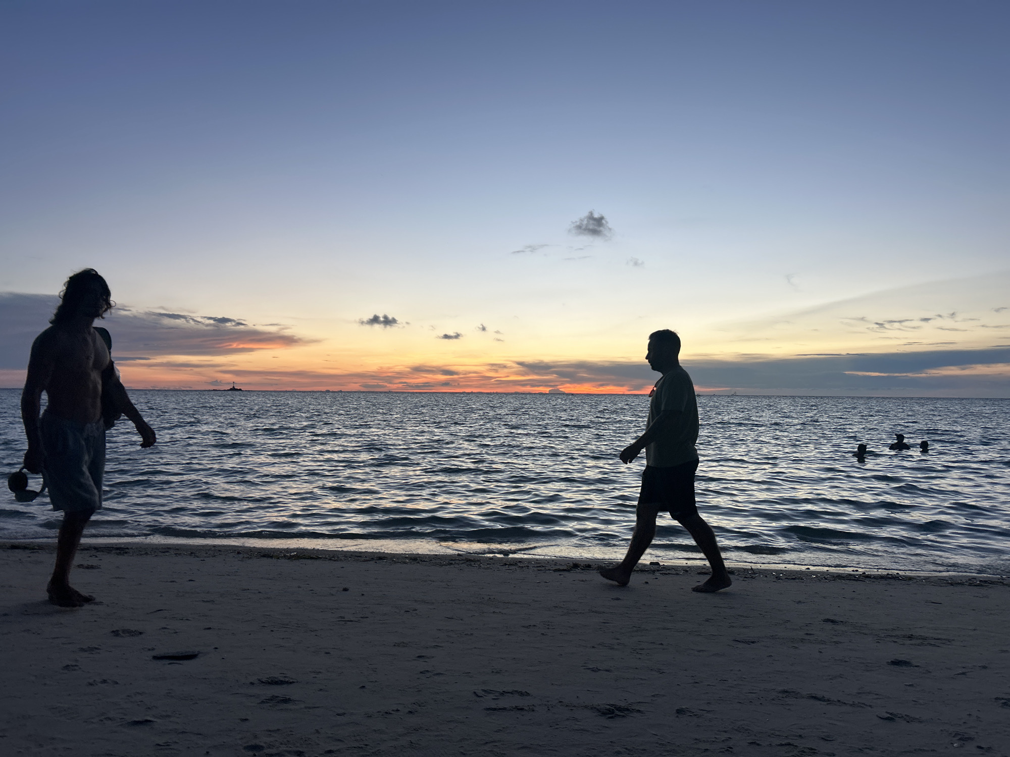 Koh Phangan beach at golden hour, crowds winding down