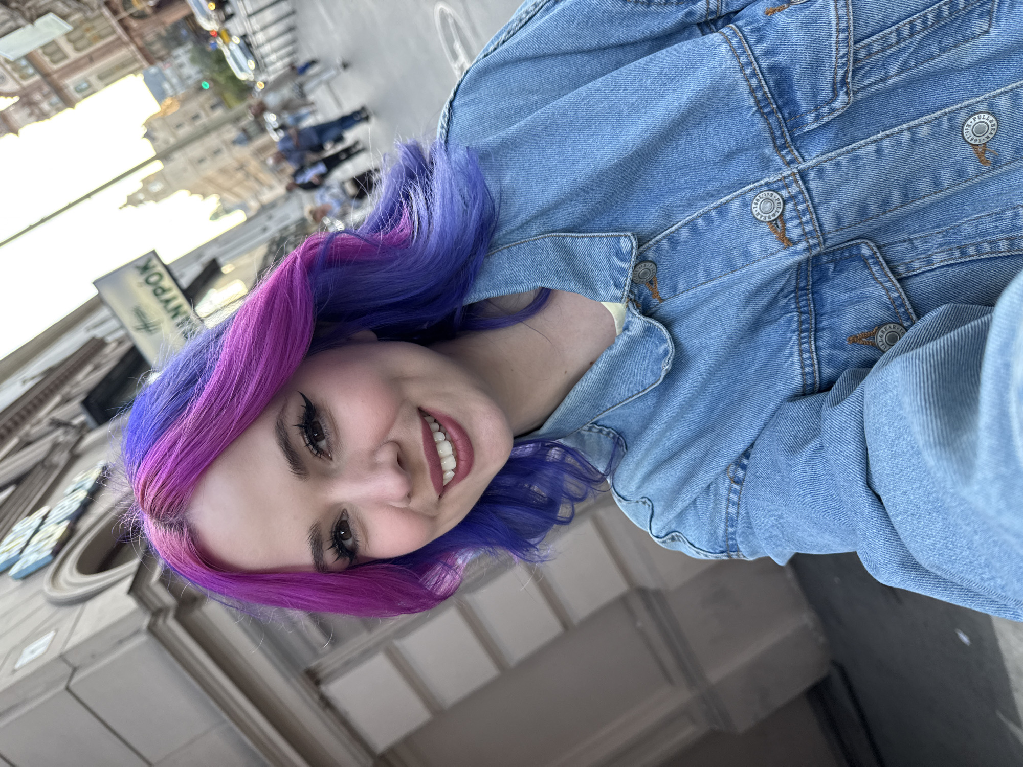 Tourist documents Budapest architecture while taking colorful hair selfies