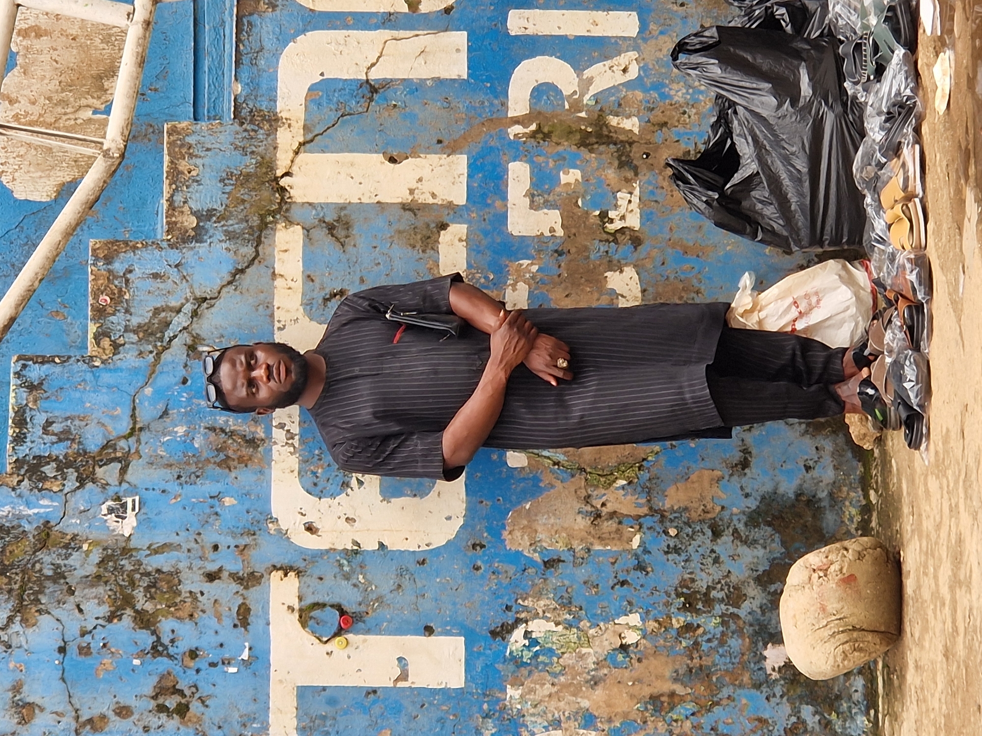 Street life near a Technicolor Nigeria storefront on a busy urban day