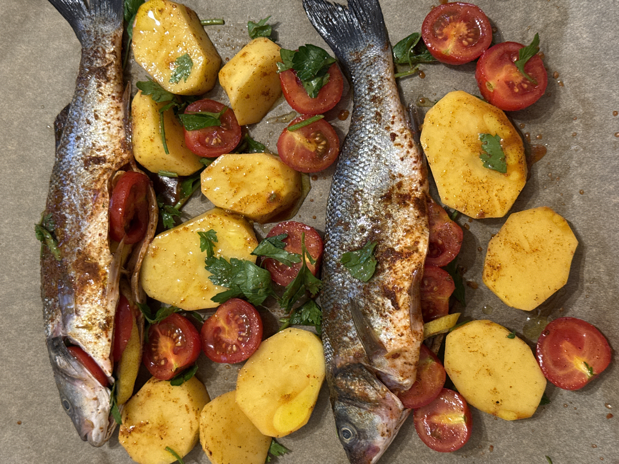 Whole sea bass prepped with tomatoes, lemon, and potatoes