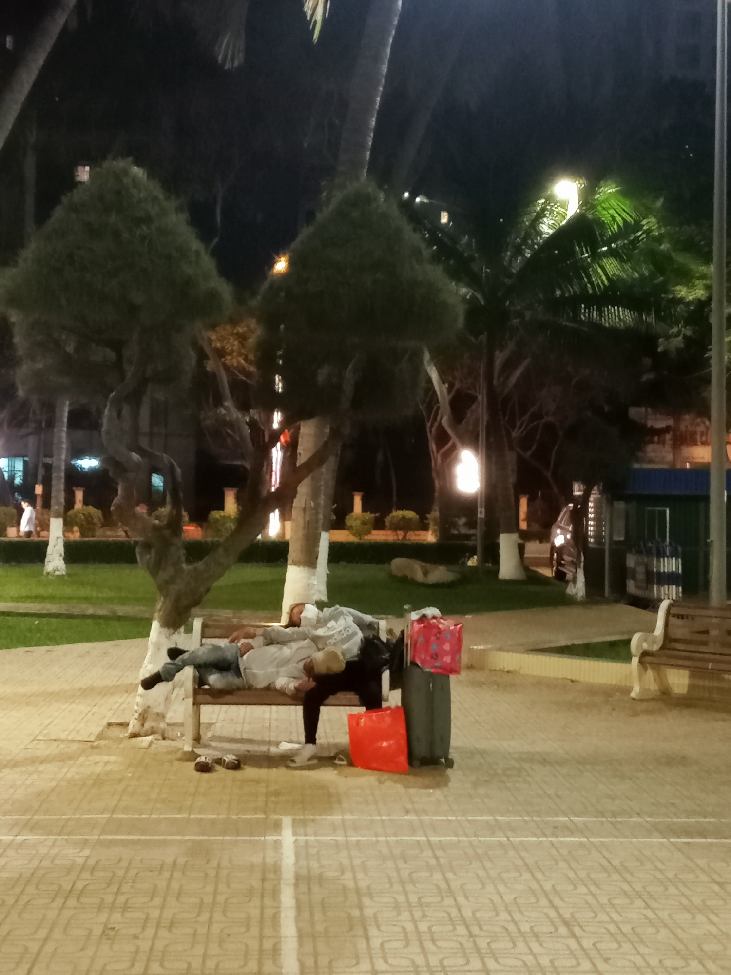 Two people rest on park bench in Nha Trang