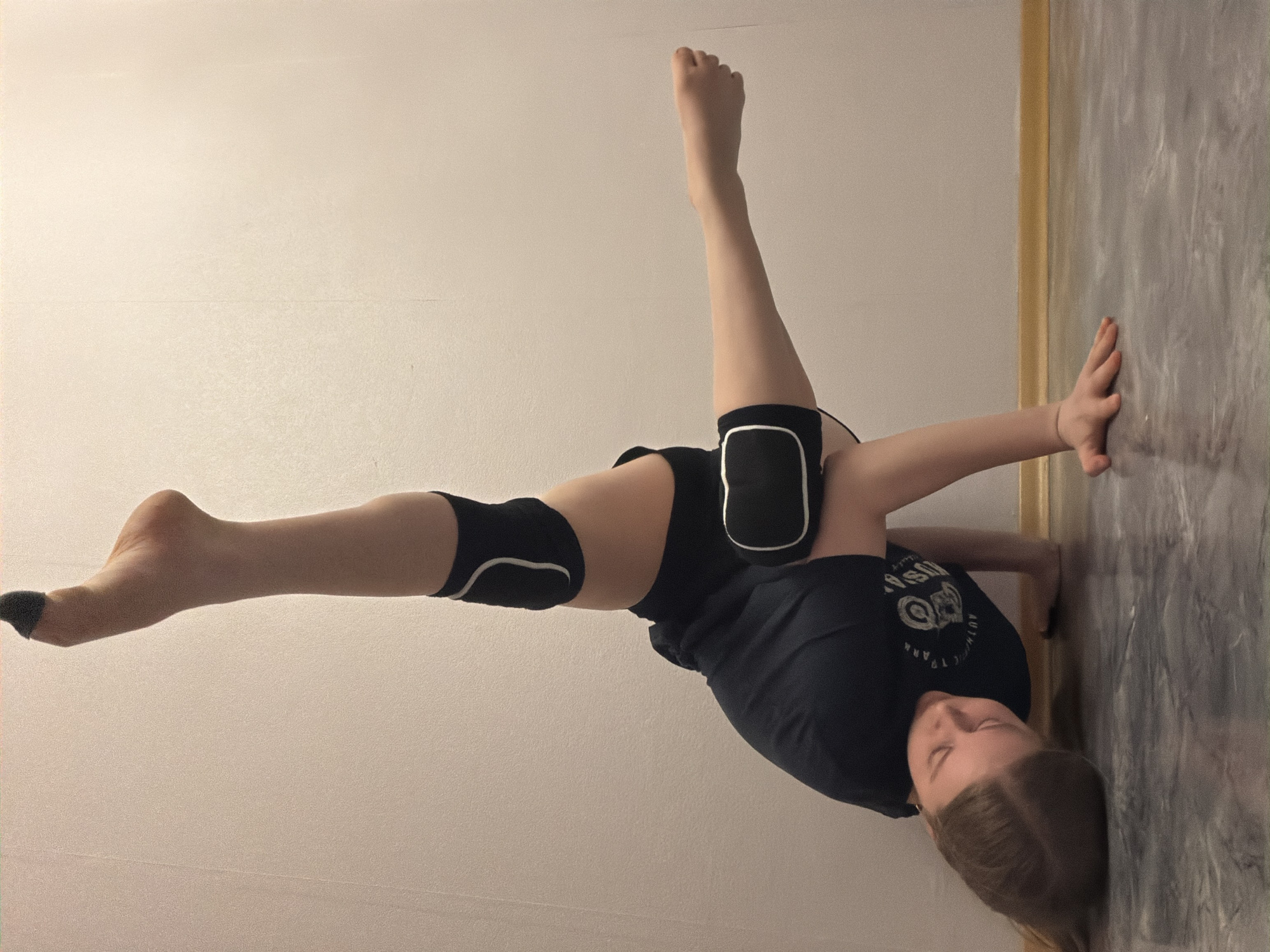 Gymnast practices wall handstands and backbends in Perm apartment