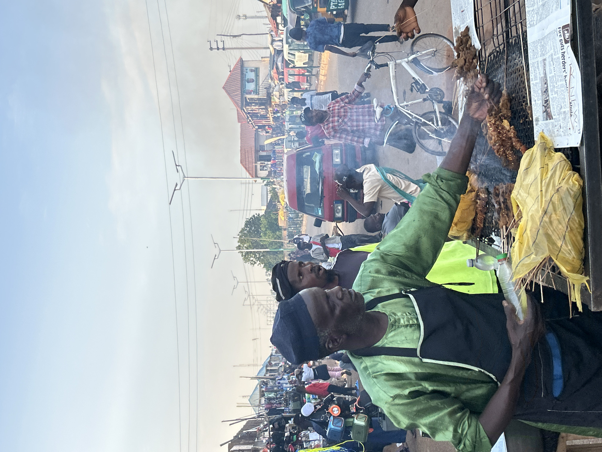 Street food vendors serve customers in Jos marketplace
