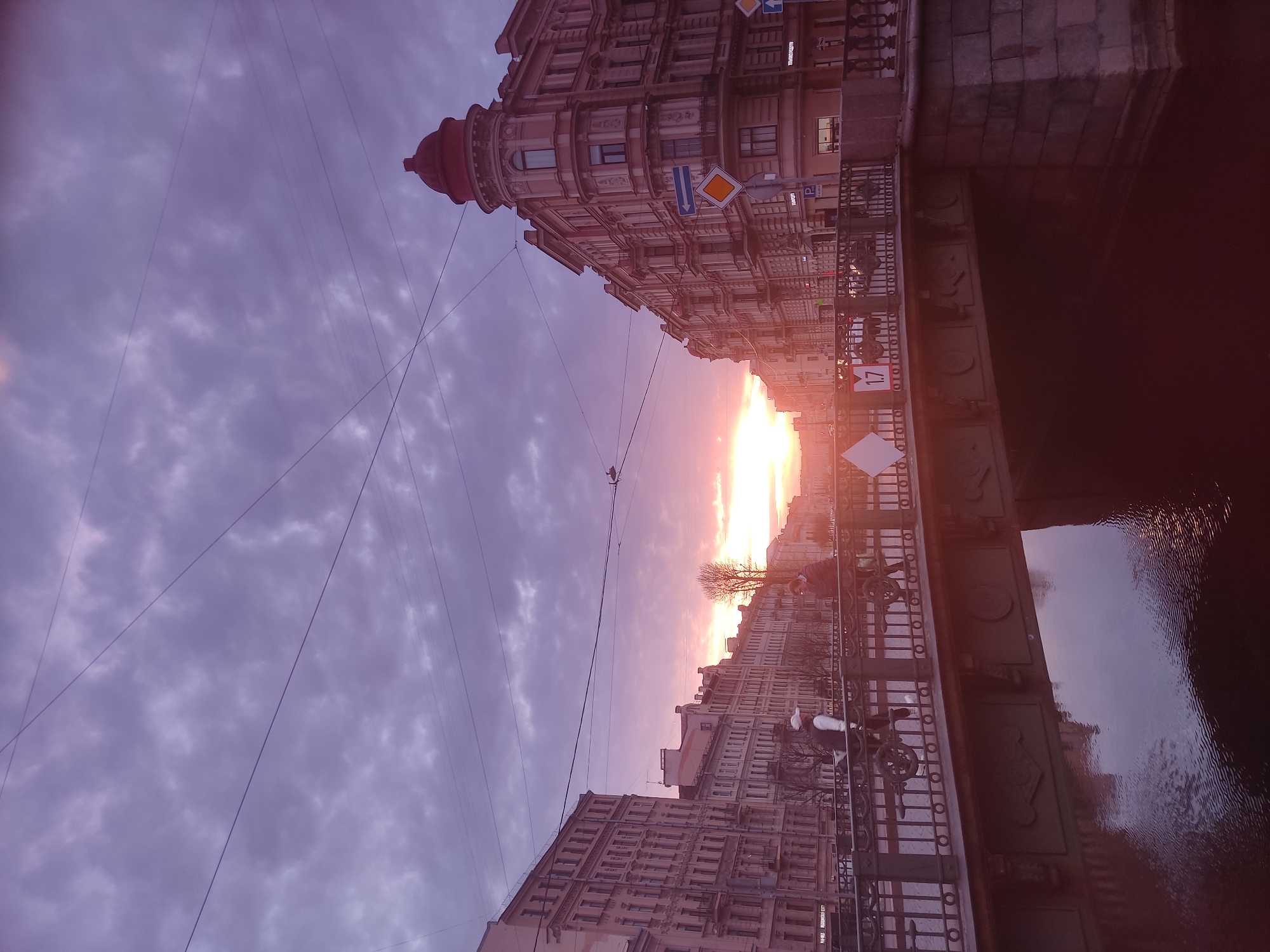 Sunset documented along Saint Petersburg canal with golden reflections