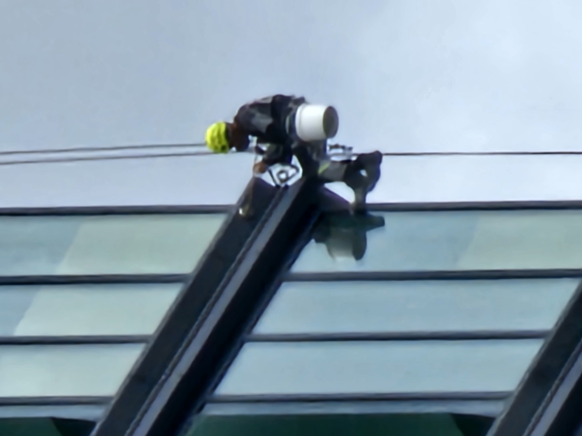 Rope-suspended crews service a Moscow glass skyscraper's exterior