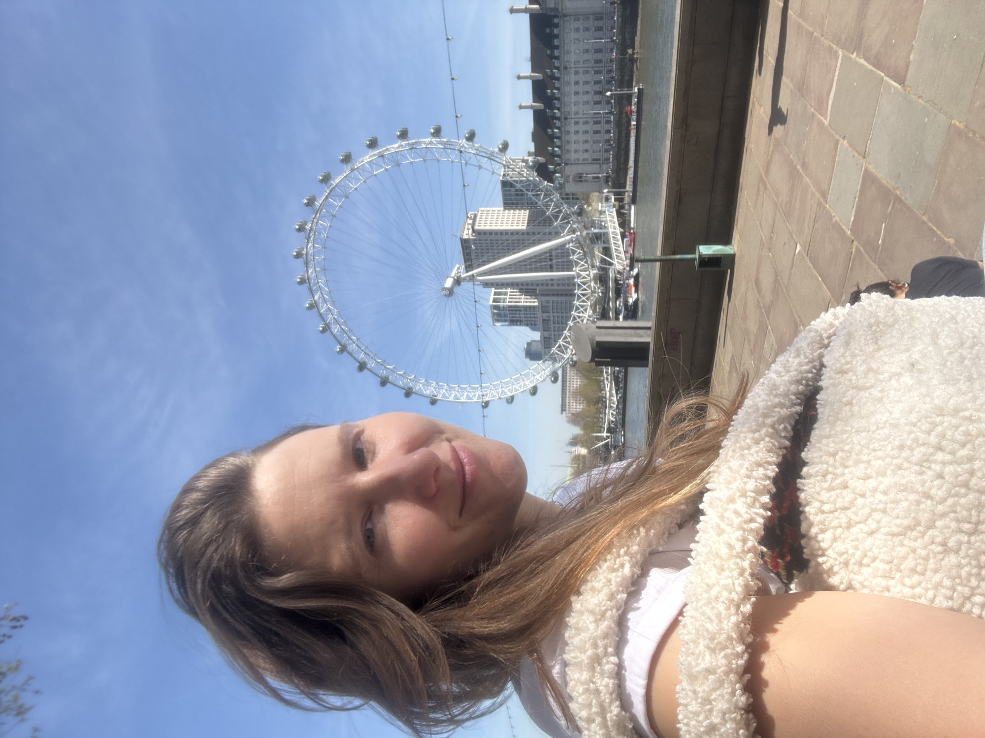 Woman takes selfies at London Eye on clear day