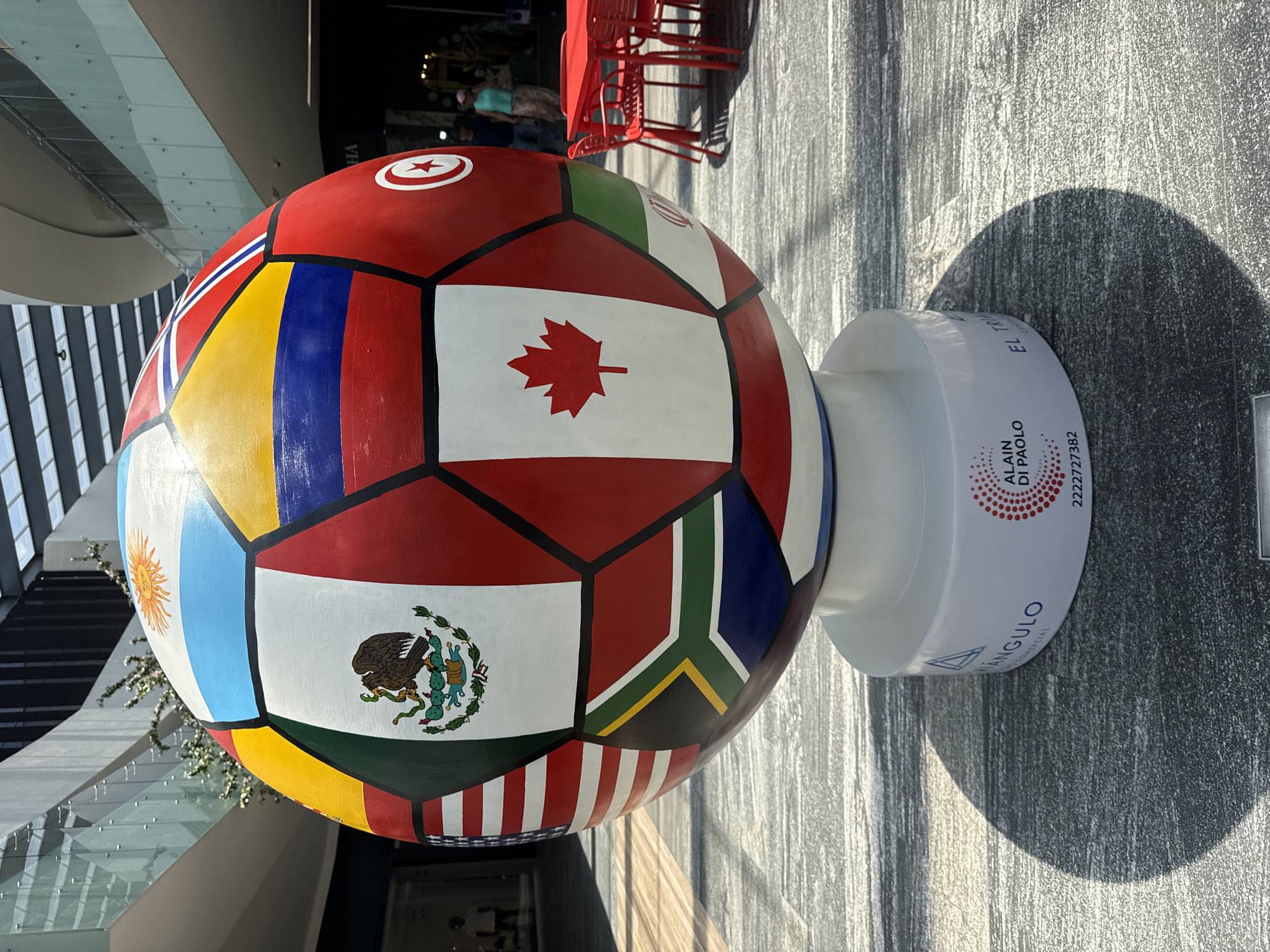 Flag-decorated soccer ball sculpture displayed in Puebla commercial space
