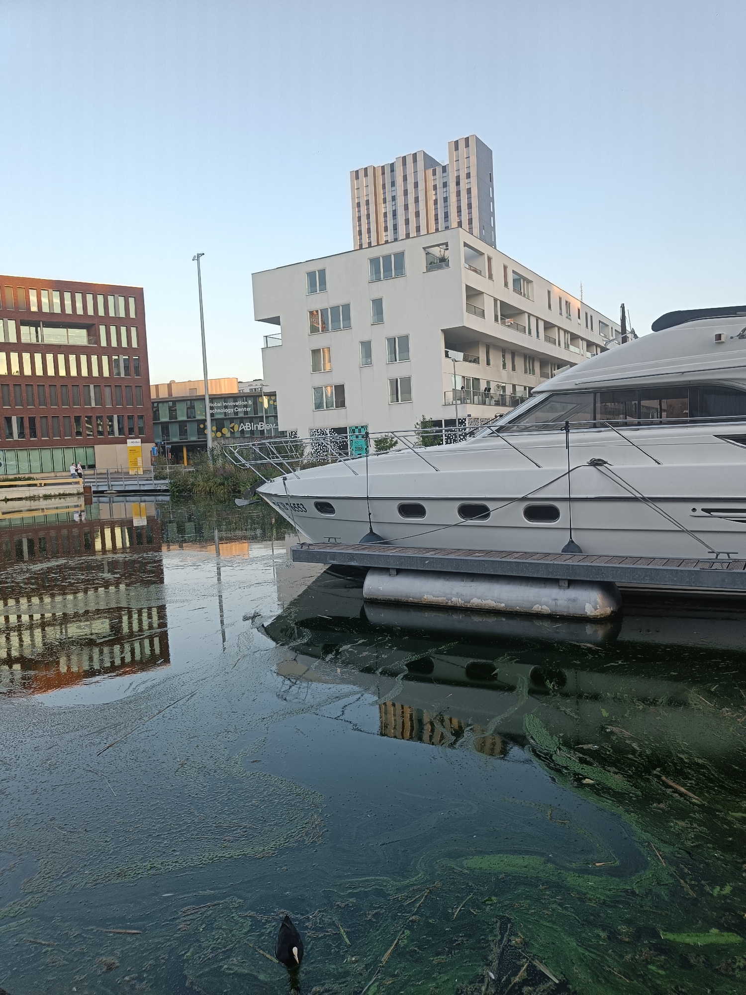 Leuven's Vaartkom waterfront: industry, modern builds, and a docked yacht