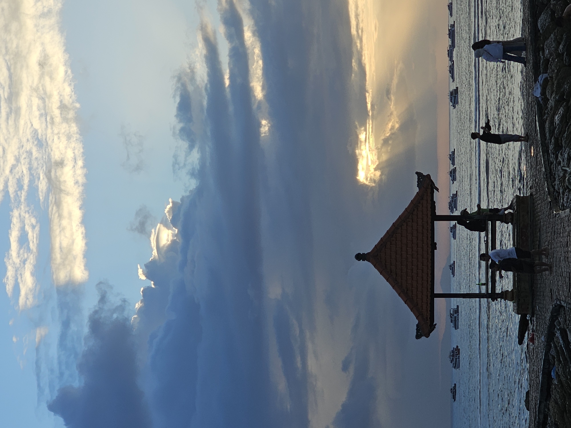 Denpasar coastline at golden hour, boats and beachgoers
