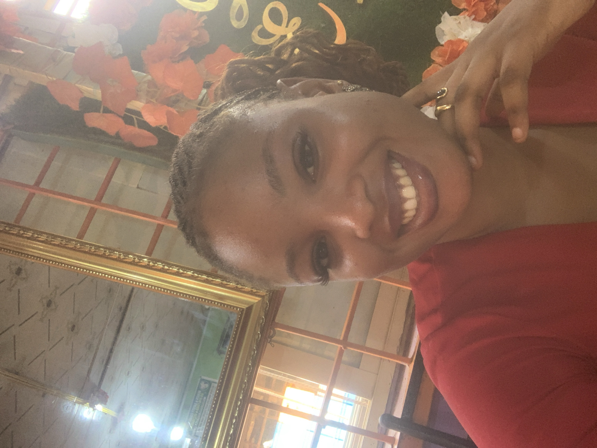 Woman photographs herself at indoor event with decorative backdrop