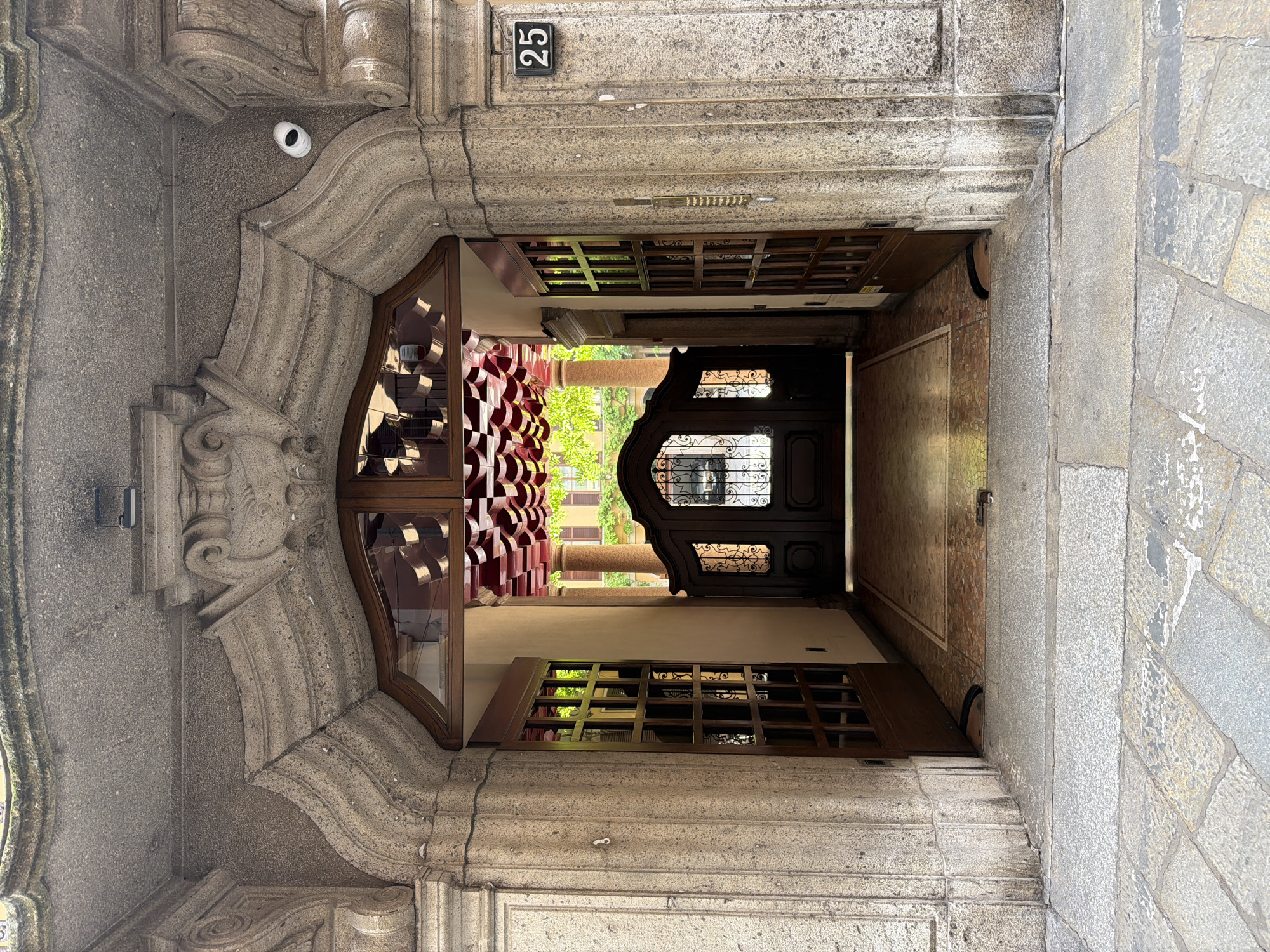 Stone building entrance with ornate archway documented in Milan