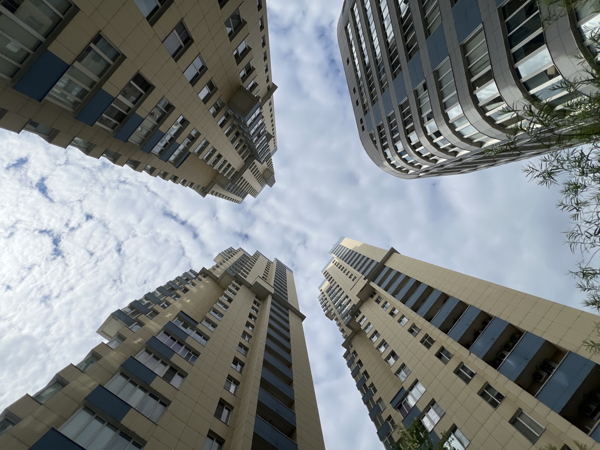 Looking up at Moscow's modern residential towers on a cloudy afternoon