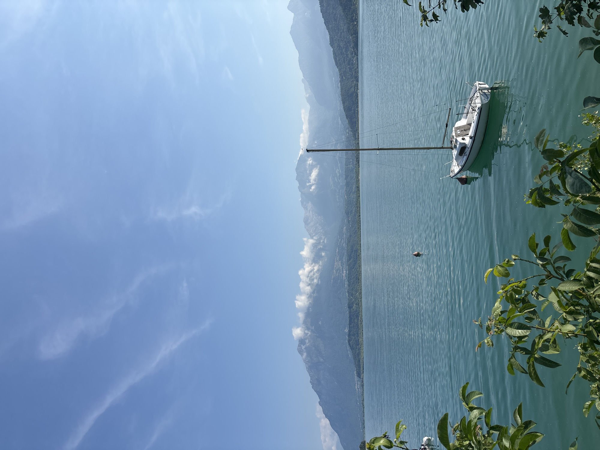 Sailboat anchored on a misty alpine lake in northern Italy