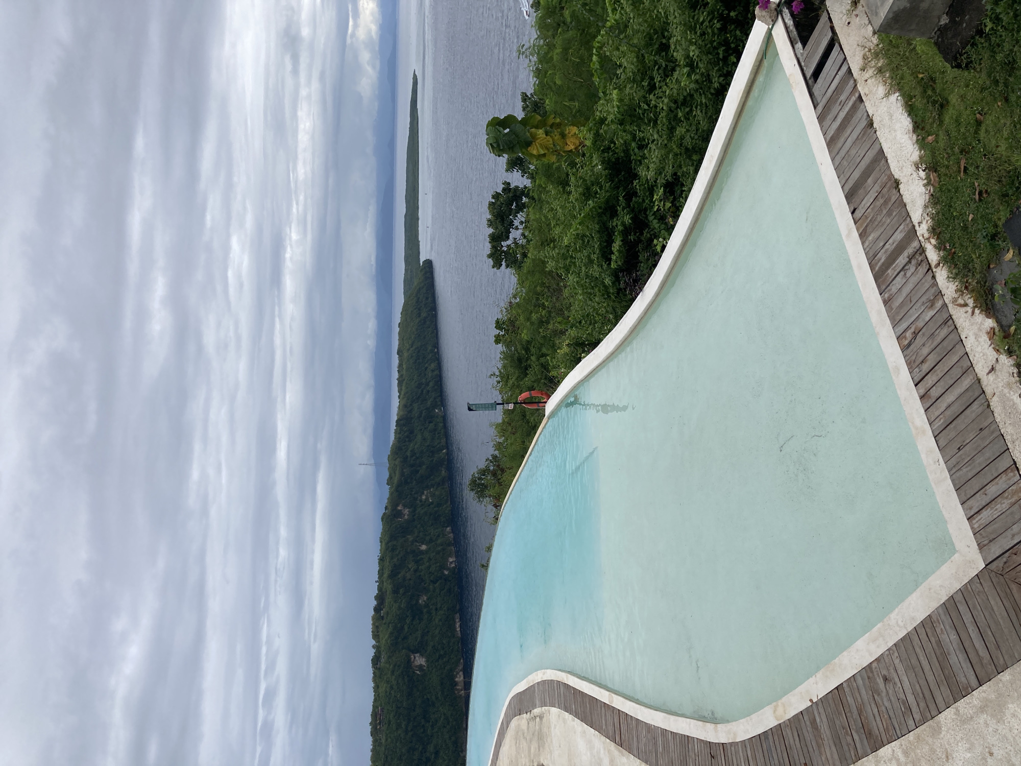 Tropical infinity pool and coastal hillside captured in early morning