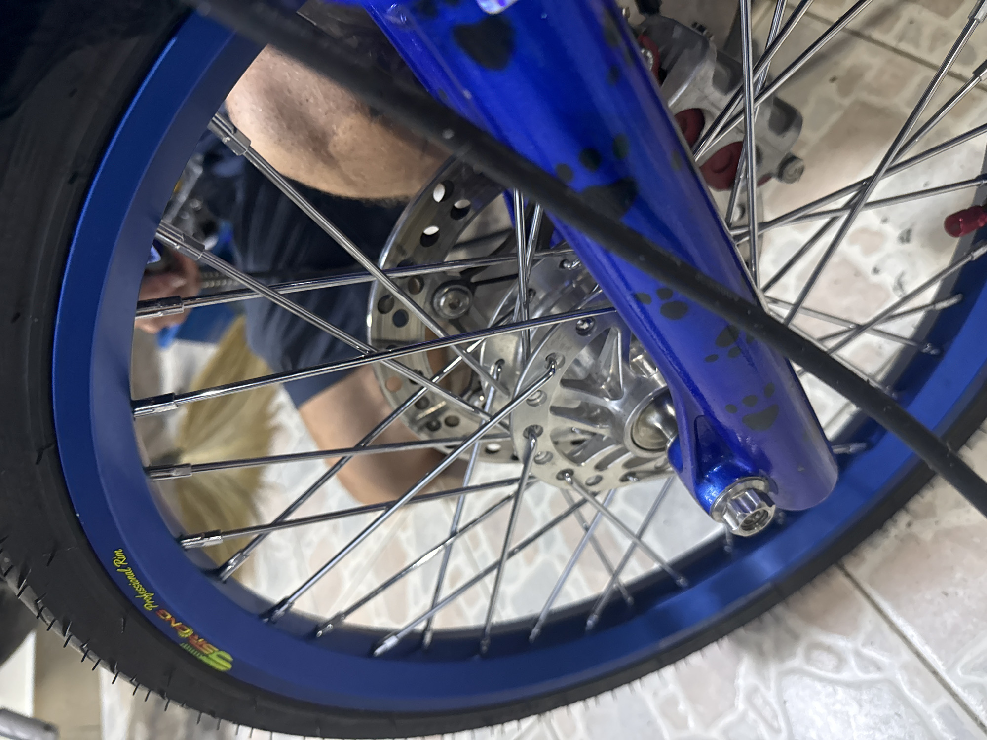 Blue motorcycle teardown and fuel prep in a Si Sunthon garage