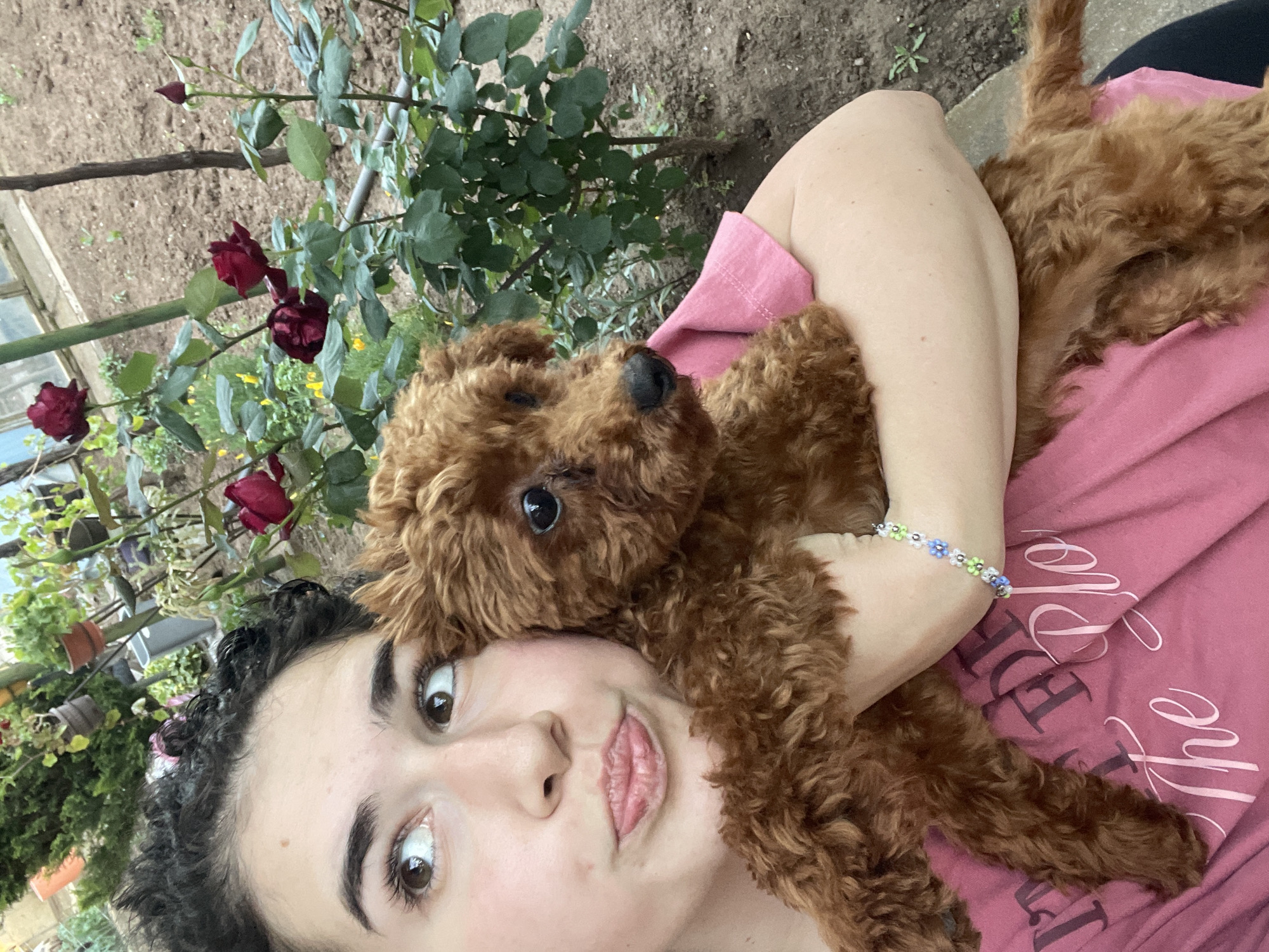 Woman plays with poodle puppy in Sofia backyard