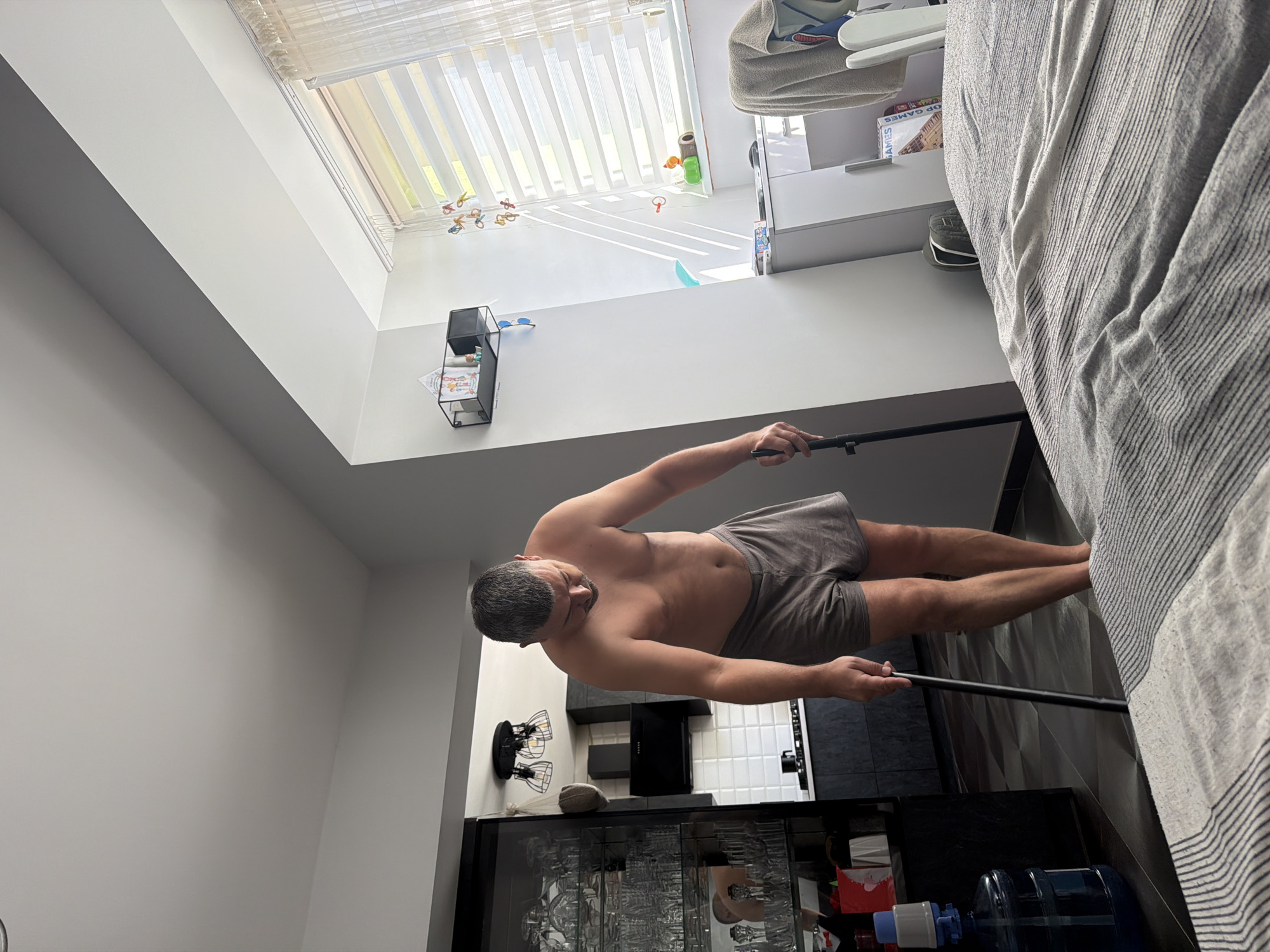 Lazy Saturday morning at home, kid on the couch, adult tidying up