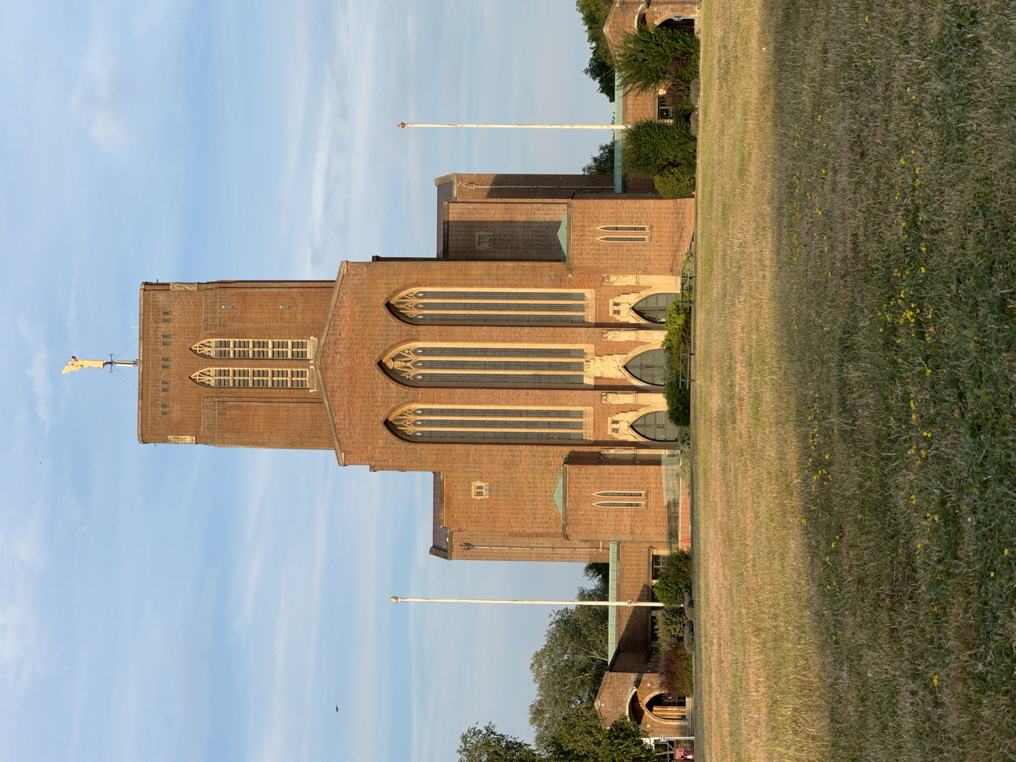 Guildford Cathedral's brick Gothic exterior on a summer evening.