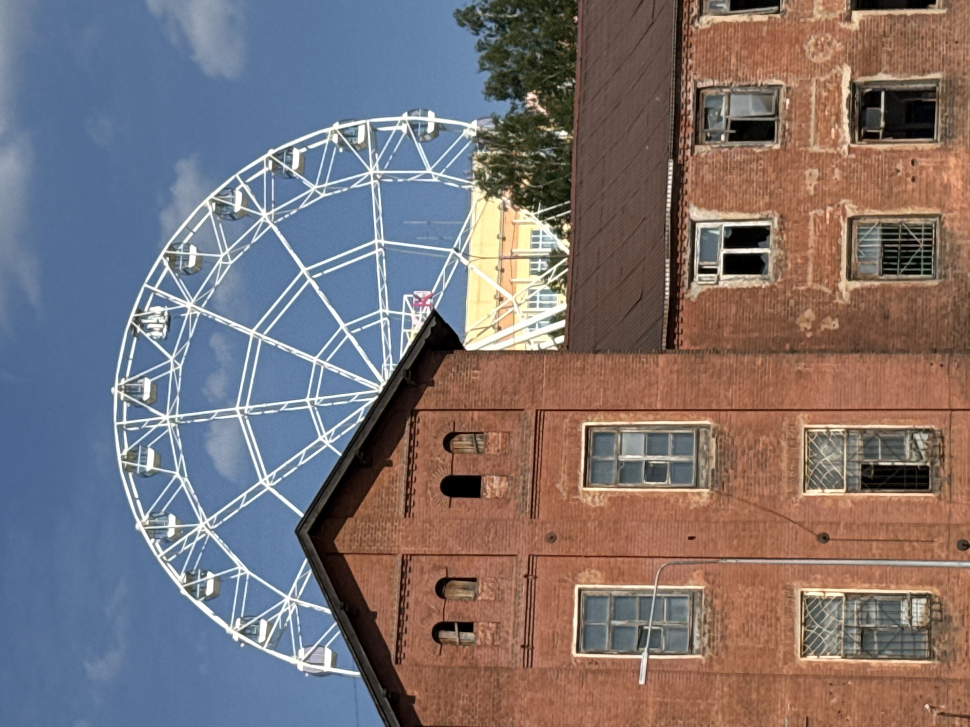 White Ferris wheel spotted against blue sky in Izhevsk