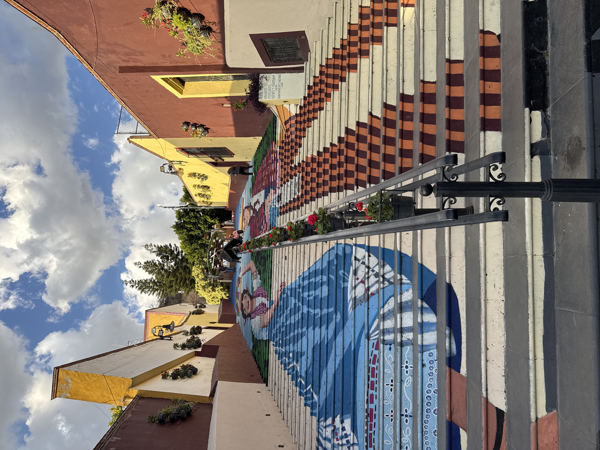 Street mural of woman in blue adorns stairs in Atlixco