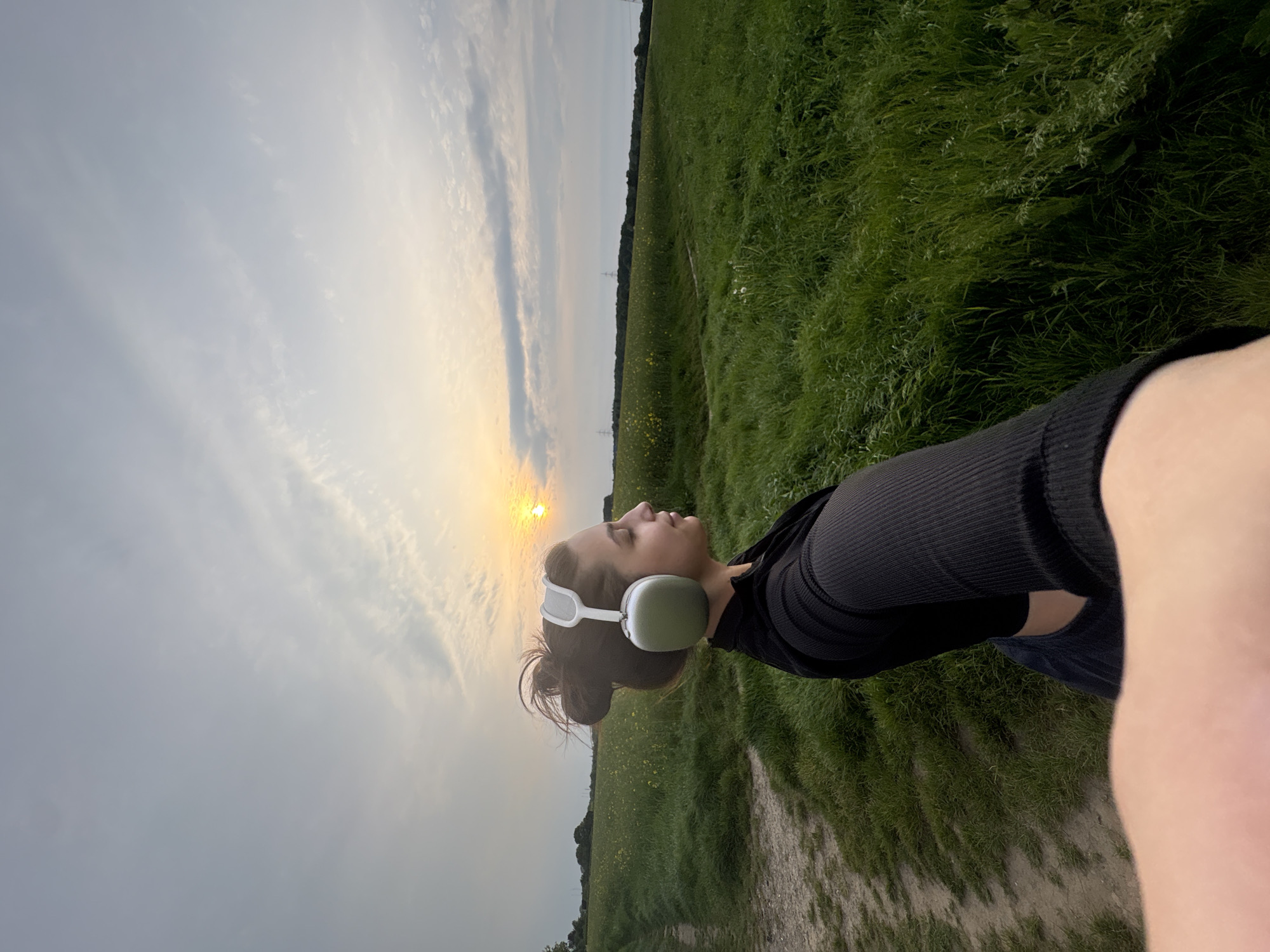 Woman takes sunset selfies in Mönchengladbach field