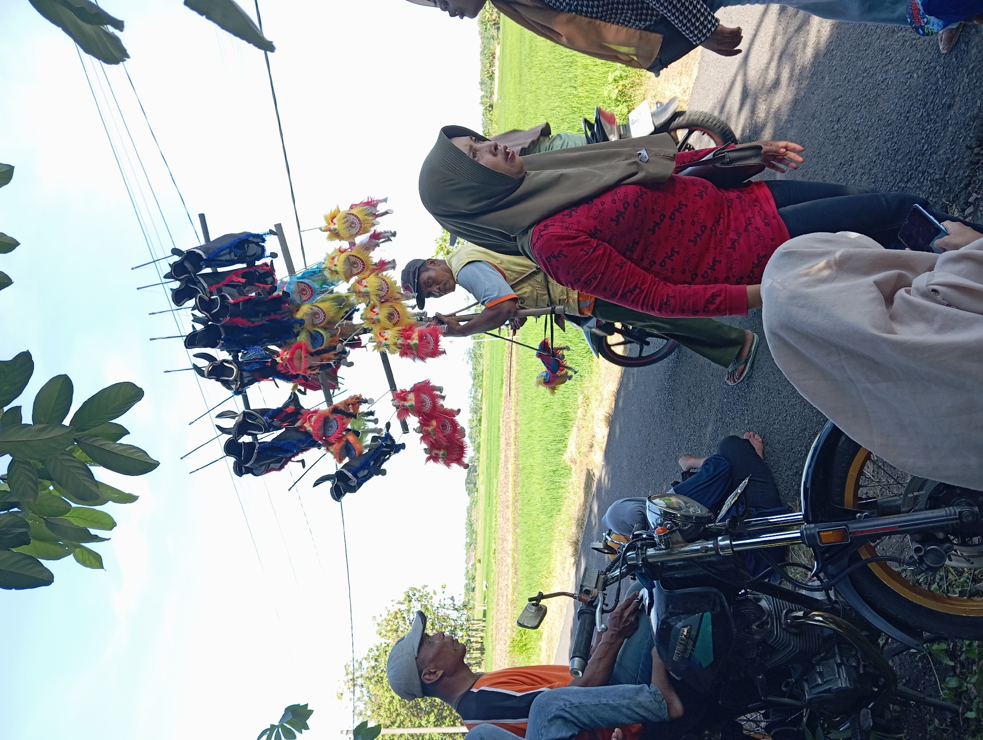 Community gathering with families, vendors, procession in rural Waung, Indonesia