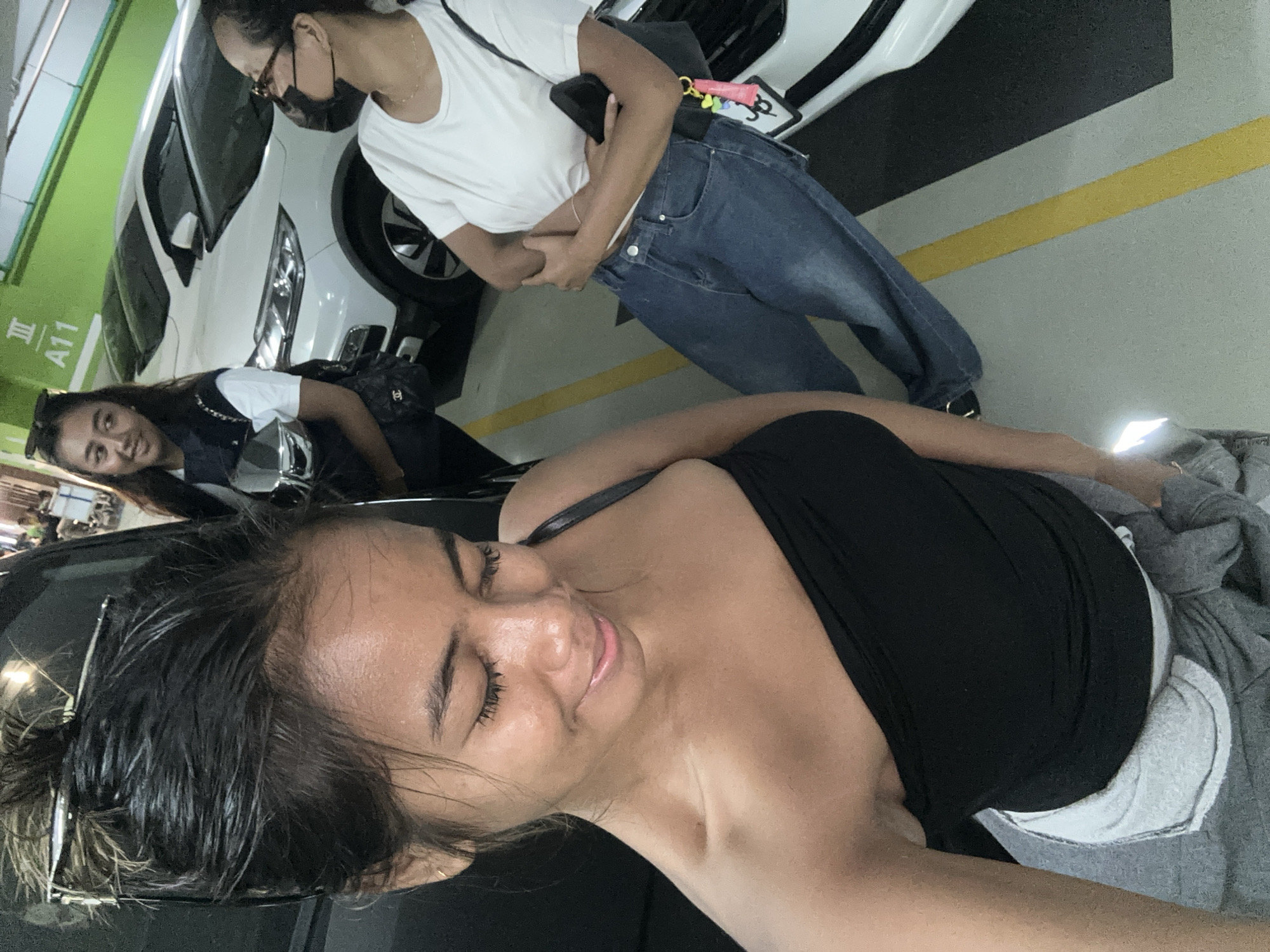 Parking garage activity in Kuta: selfies and a car inspection