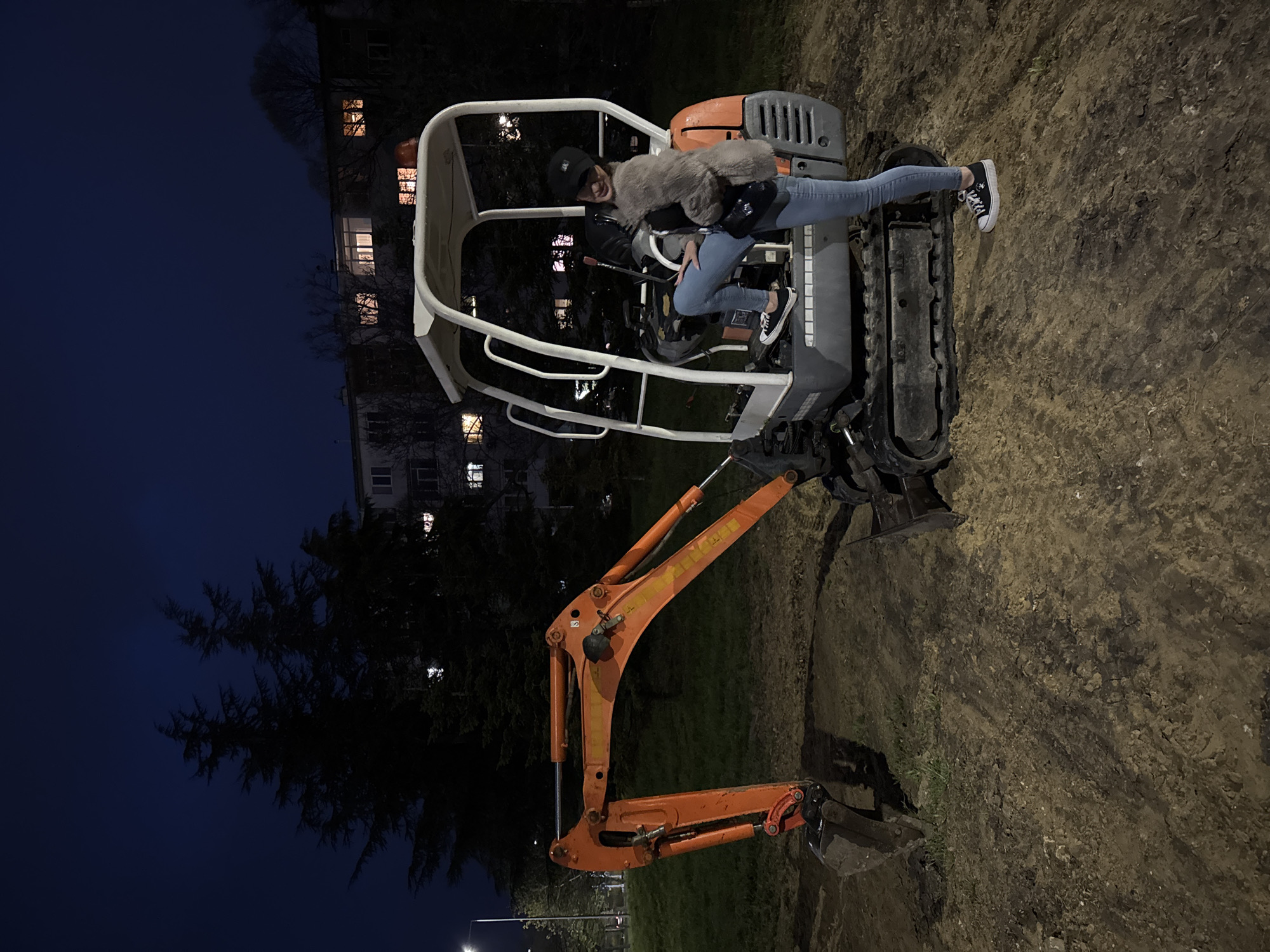 Woman poses on excavator at night in Varna
