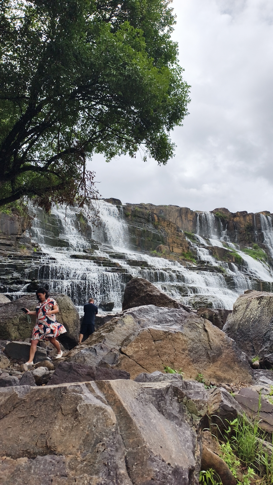 Exploring a tiered waterfall on rocky terrain in Tân Phú