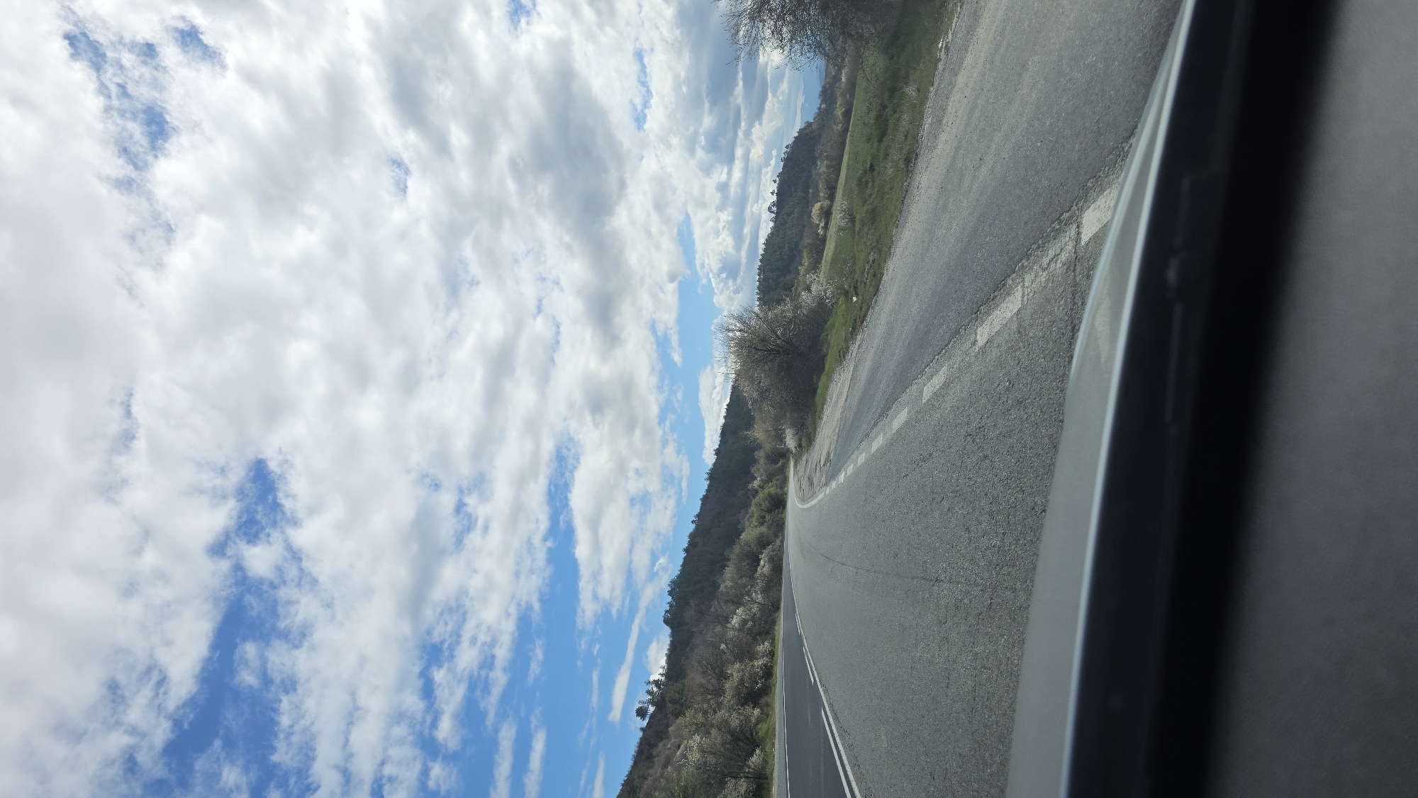 Vehicle drives through hilly countryside near Kocherinovo, Bulgaria