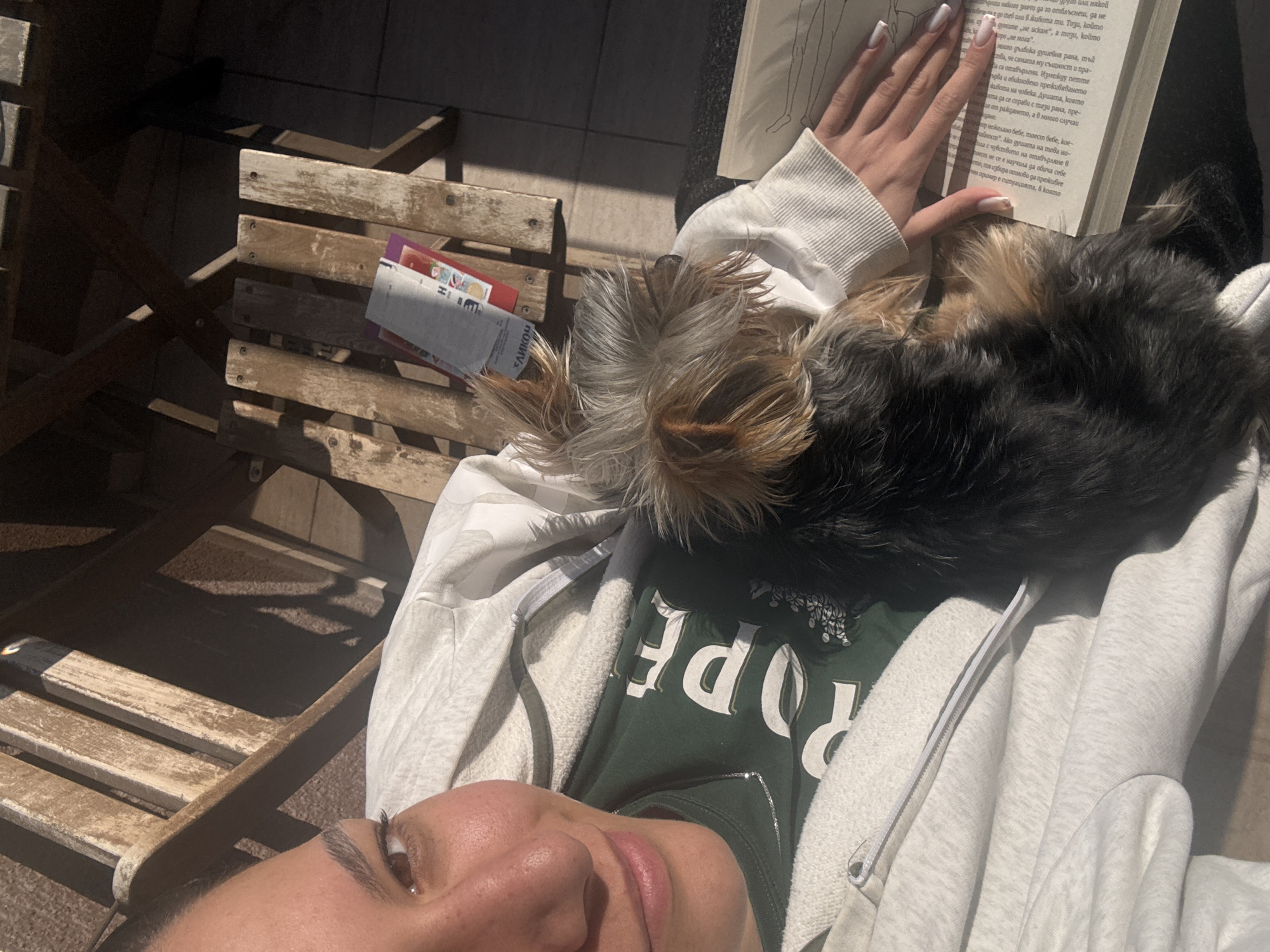 Woman enjoys quiet afternoon reading with Yorkshire Terrier companion