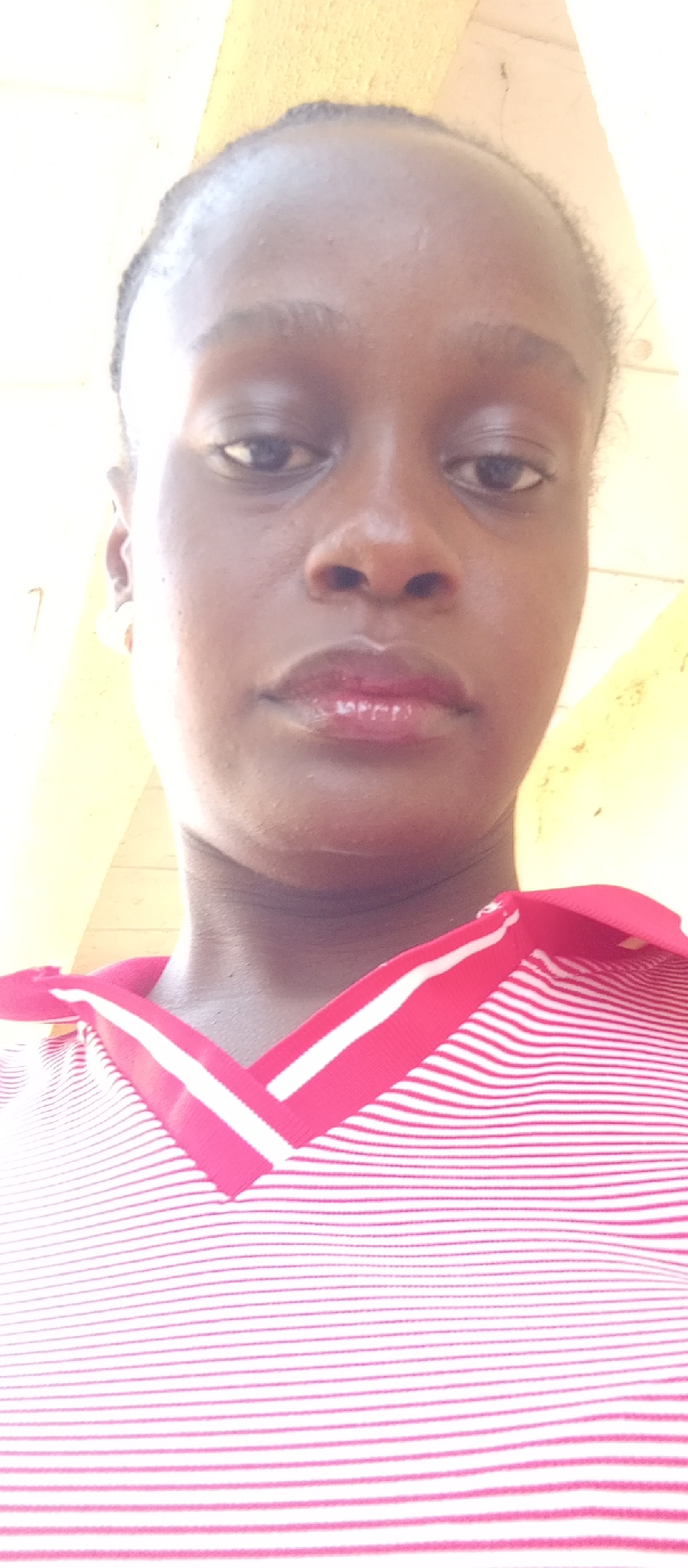 Woman takes selfies in striped shirt in Akwanga, Nigeria