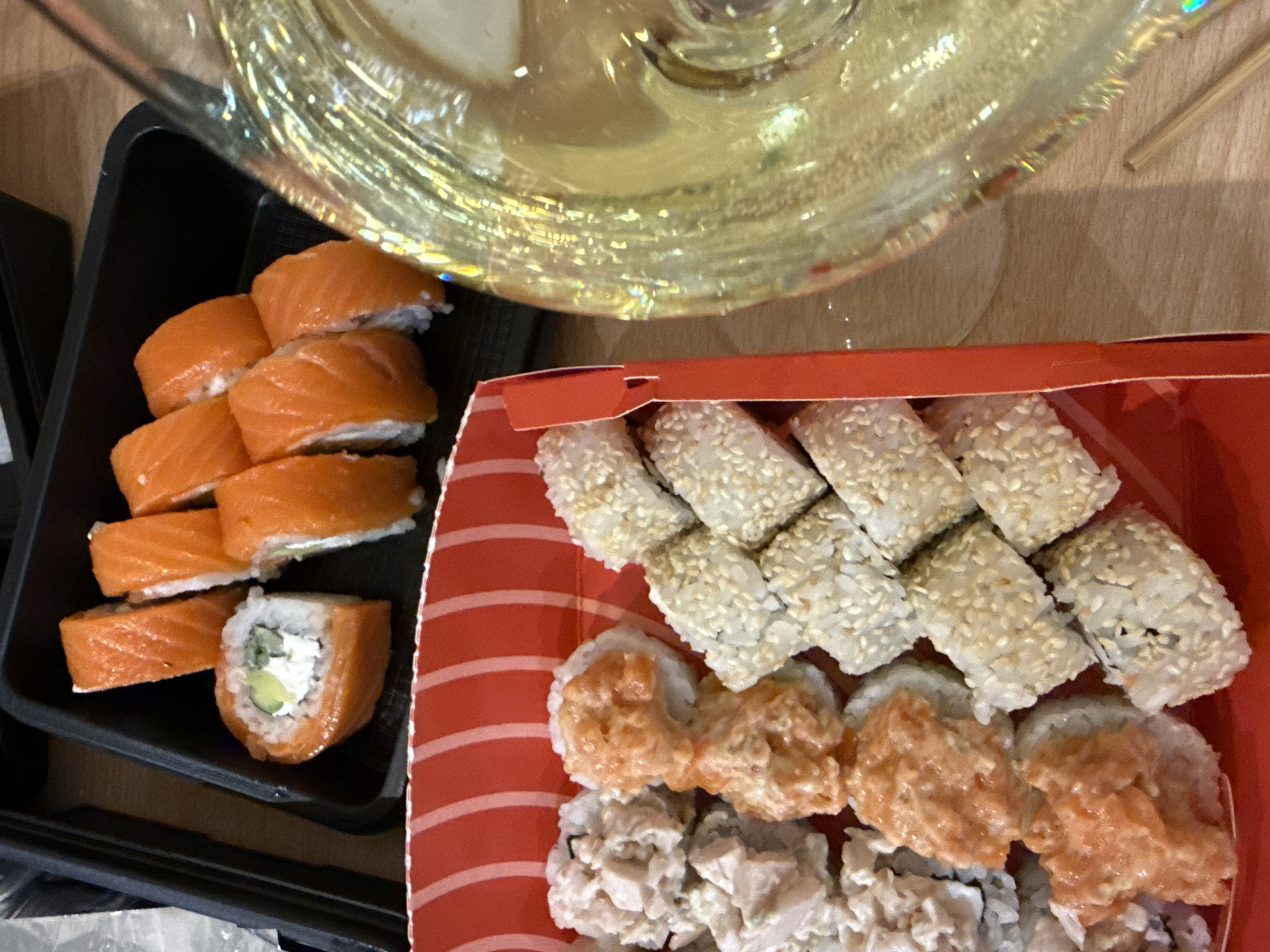 Sushi containers photographed on wooden table in Kazan