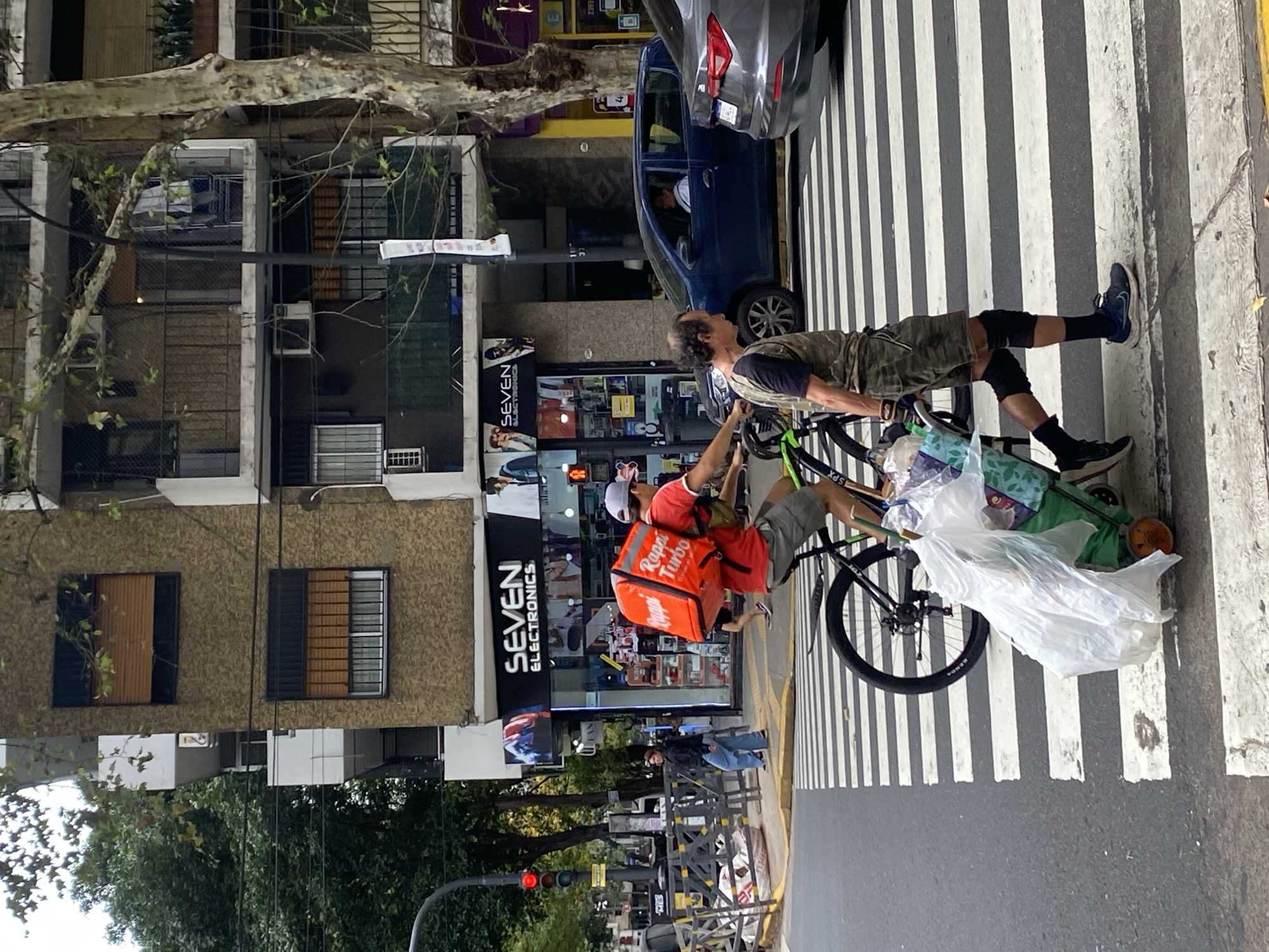 Buenos Aires street activity includes delivery cyclists, construction work