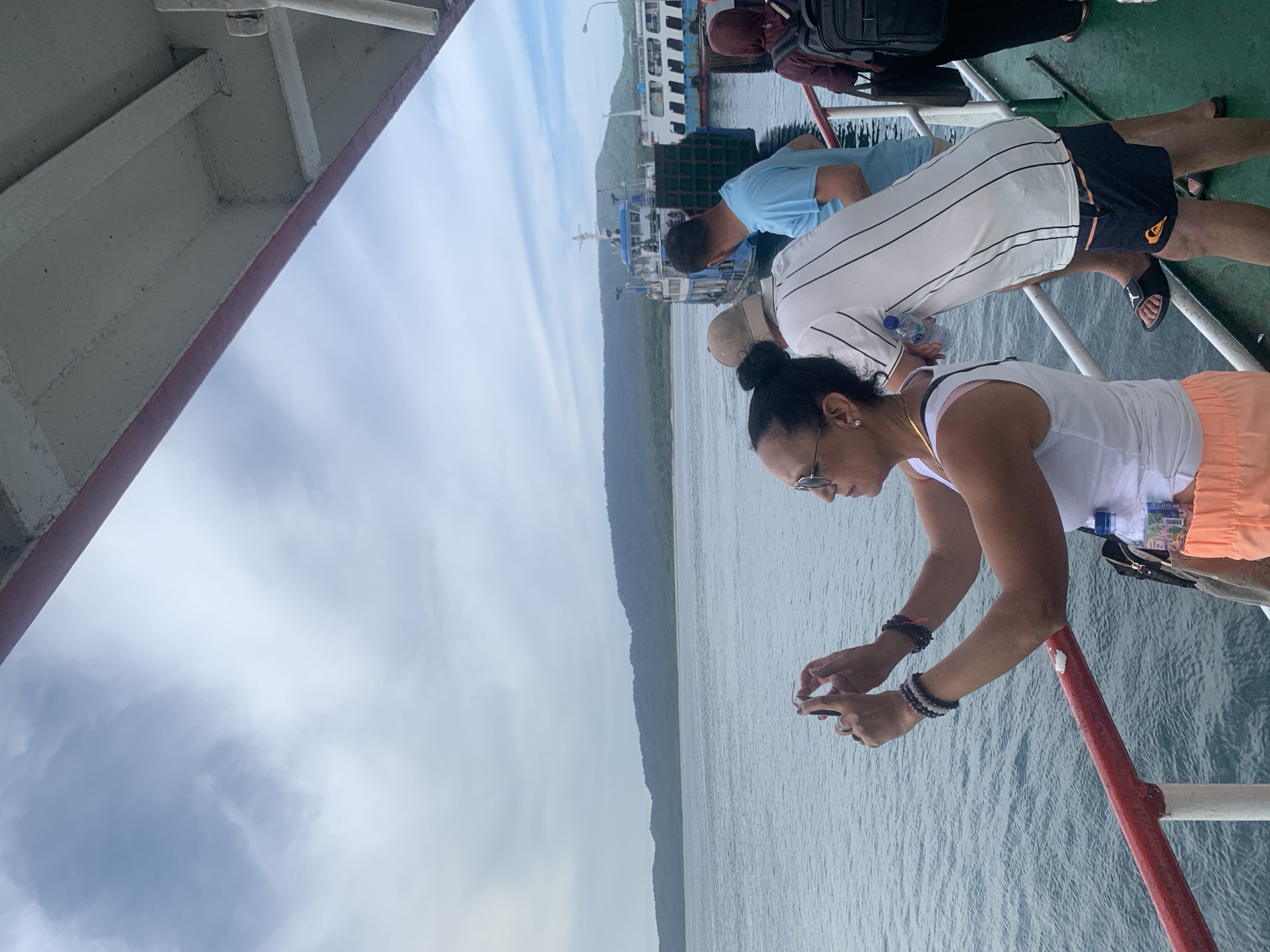 Ferry passengers photographing and moving about vessel near Melaya, Indonesia