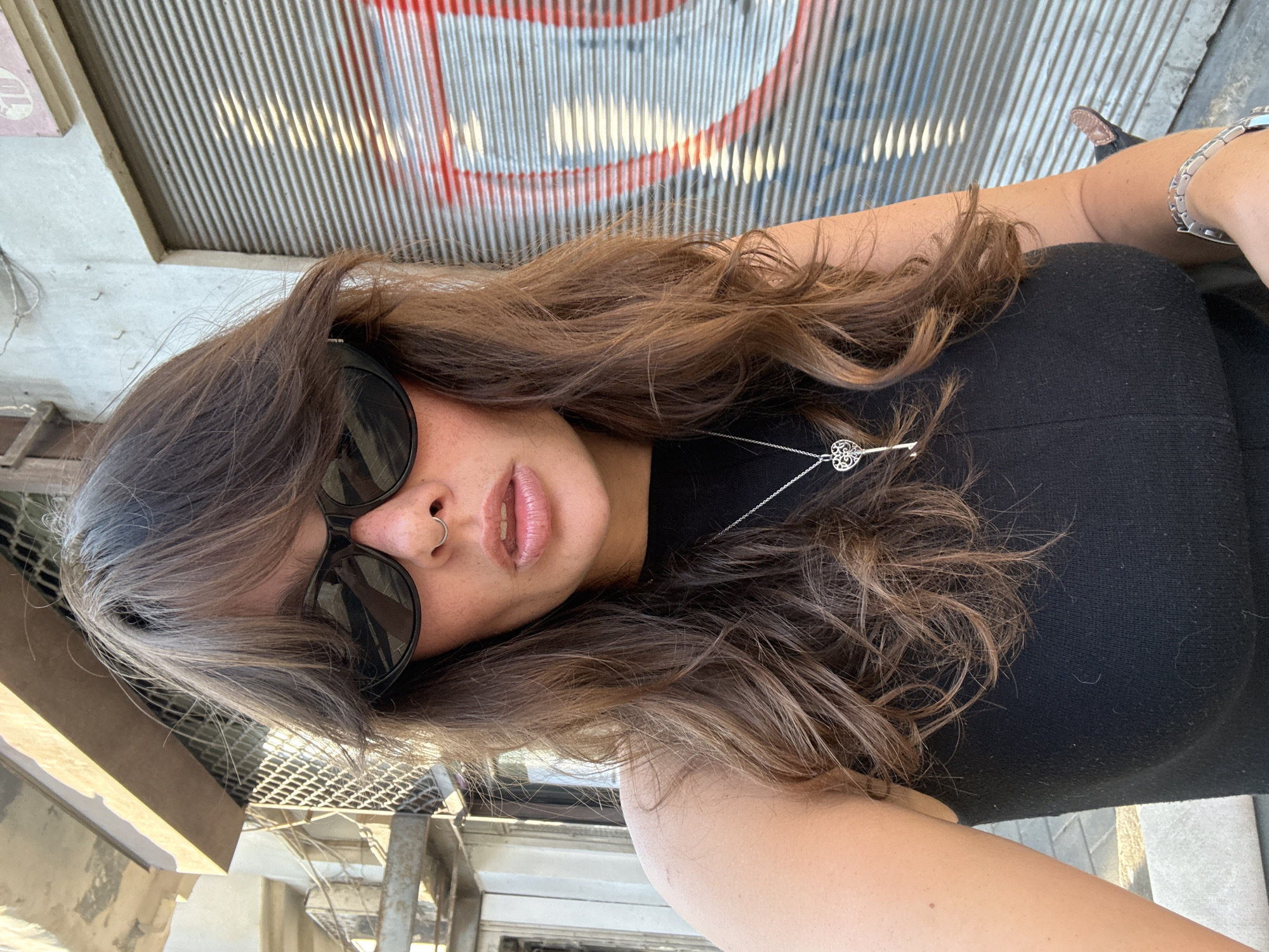 Selfie in front of a red graffiti-tagged security gate, Tel Aviv