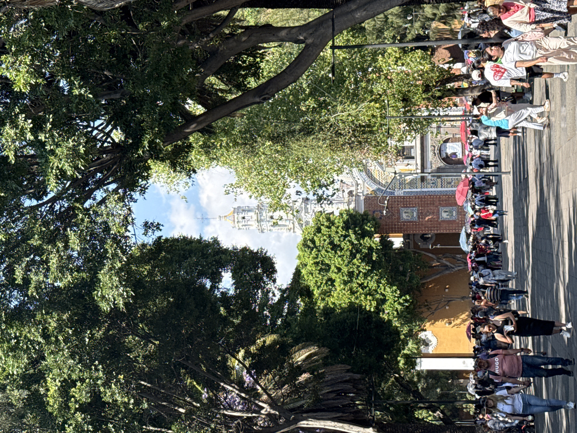 Evening crowd walks tree-lined street near Templo de San Francisco
