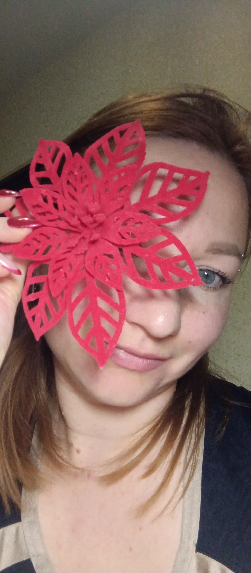 Woman poses with red felt flower, decorative objects photographed
